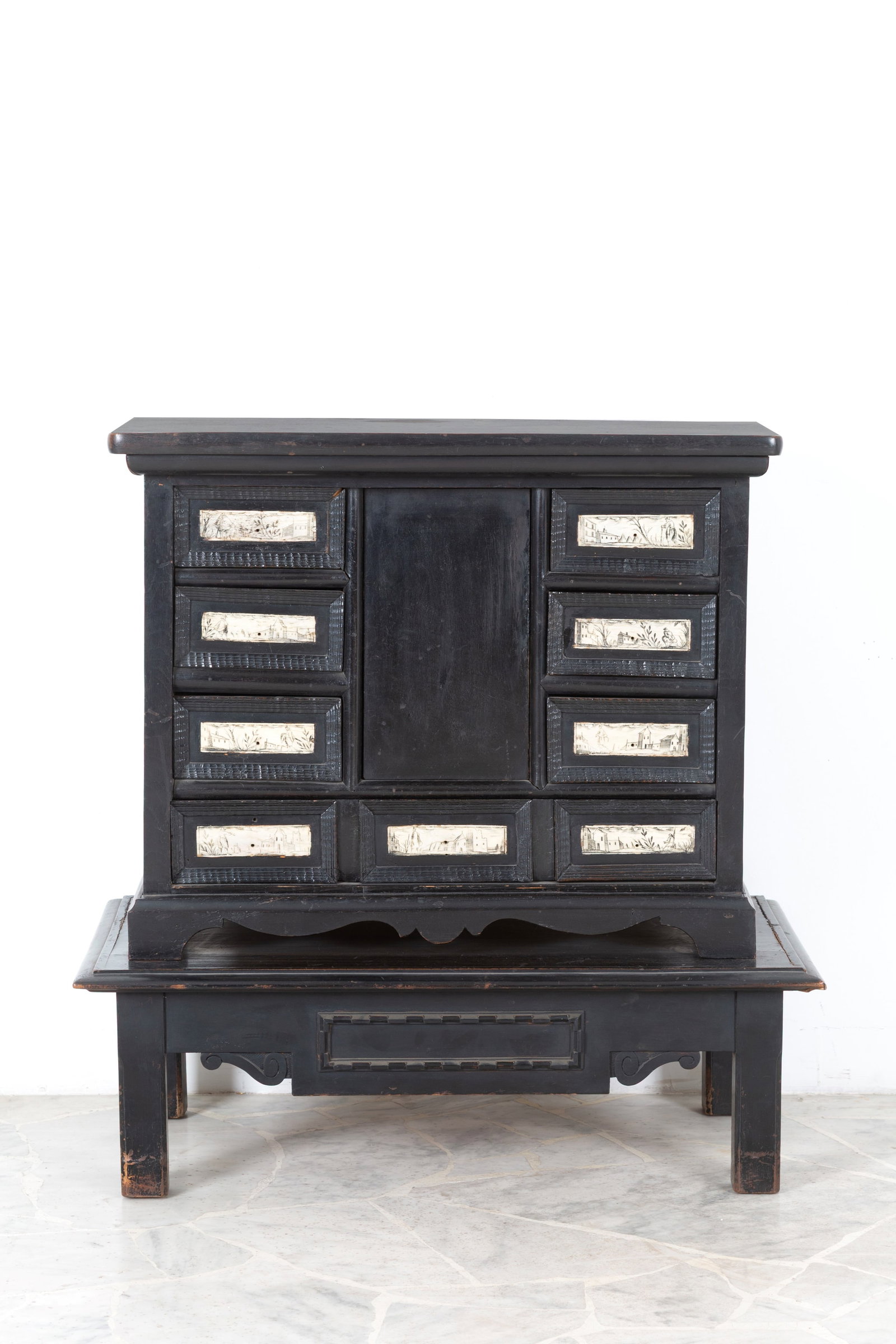 Monetiere ebanizzato: Ebonized coin cabinet with wooden base and eight drawers inlaid panels depicting scenes from everyday life, a central door painted and lacquered in the inside part with four drawers. Late 17th century