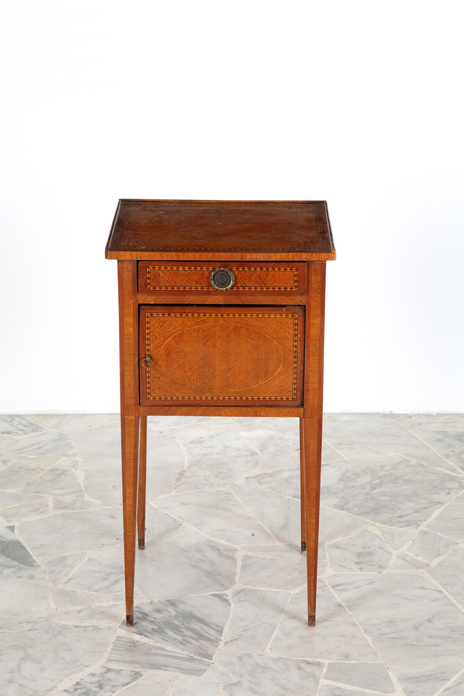 Comodino lastronato: Bedside table with tall tapered legs, inlaid and trimmed with various woods. Late 18th century. Minor defects. 73x40x33 cm approx. Comodino a gamba alta rastremata, intarsiato e filettato in legni