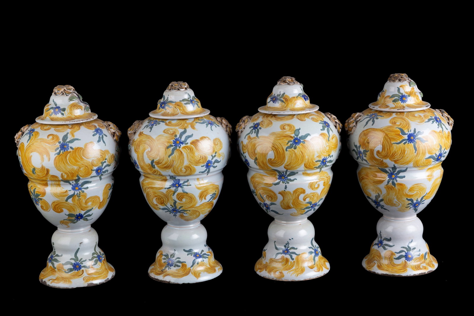 Four majolica vases: Four painted majolica vases with lids decorated with floral motifs. 18th century. Defects and missing parts. 37x20 cm approx. Quattro vasi con coperchio in maiolica dipinta decorata a motivi floreali.