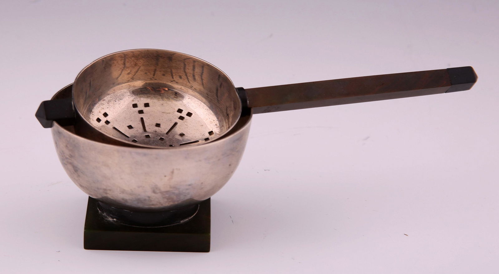 WALLACE STERLING SILVER BOWL & STRAINER 3725: WALLACE STERLING SILVER BOWL & STRAINER 3725 American sterling silver bowl and handled strainer by Wallace Silversmiths. Pierced strainer and bowl with green / brown Bakelite accents at handle and bas