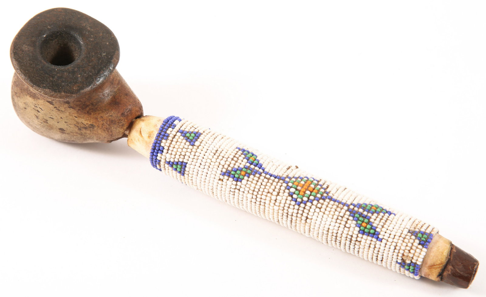 20TH C. SIOUX ELBOW PIPE WITH BEADWORK: 20TH C. SIOUX ELBOW PIPE WITH BEADWORK Sioux Native American elbow pipe made of stone, hide, and wood, with beadwork to the hide. Bowl is made of a carved stone material. Circa 20th century. Size: 8.5