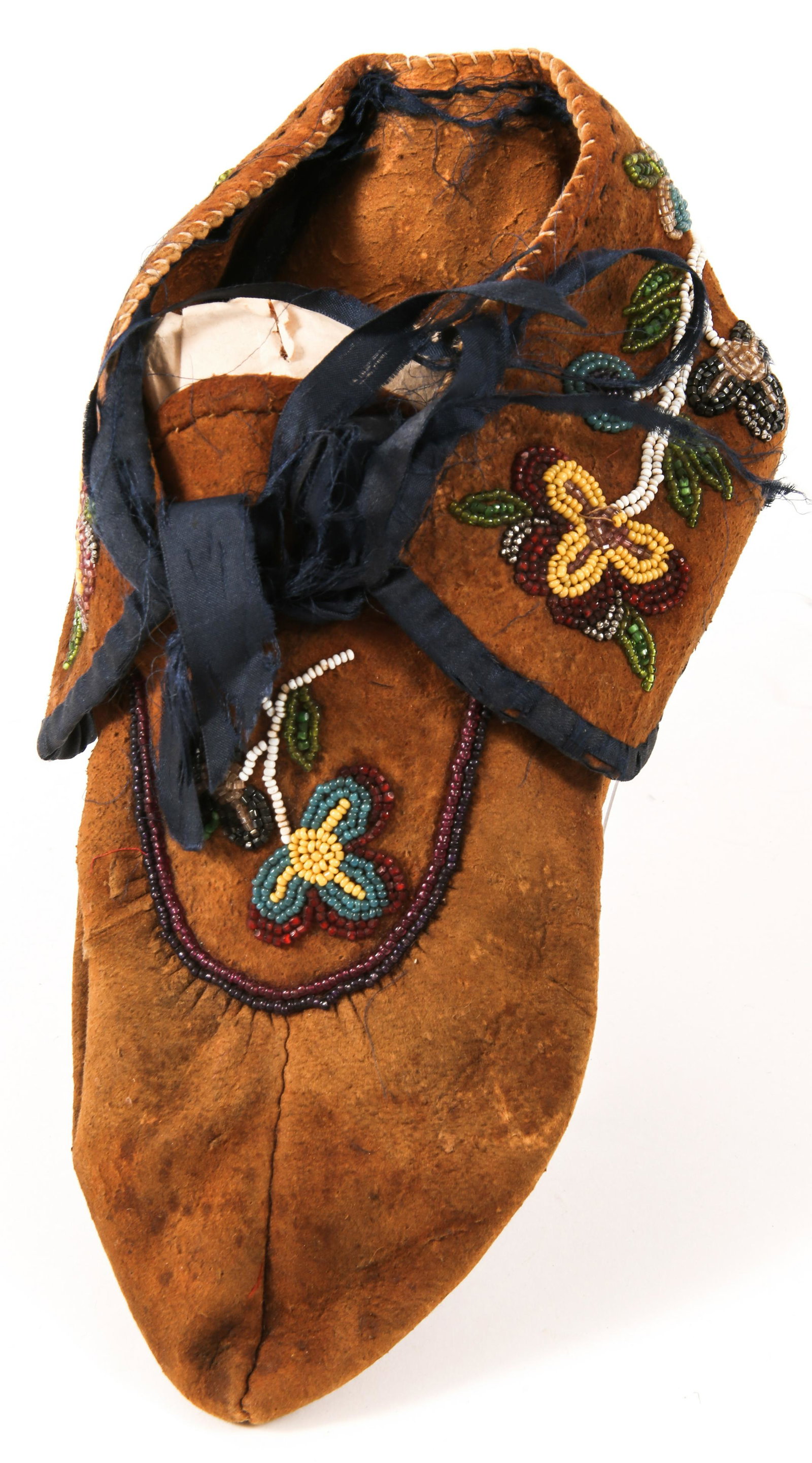 LATE 19th C. OJIBWE NATIVE AMERICAN BEADWORK MOCCASIN: LATE 19th C. OJIBWE NATIVE AMERICAN BEADWORK MOCCASIN Single Ojibwe moccasin, made of brain tanned deer hide and adorned with silk trim and beadwork. Circa late 19th century. Size: 9" sole length