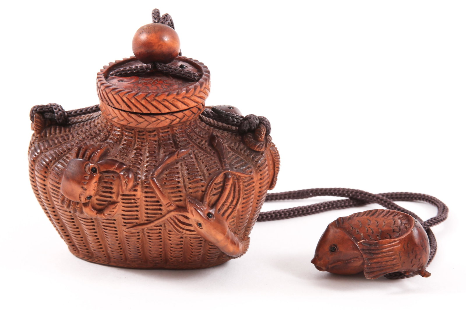 JAPANESE CARVED BOXWOOD TONKOTSU TOBACCO BOX NETSUKE: JAPANESE CARVED BOXWOOD TONKOTSU TOBACCO BOX NETSUKE Japanese carved boxwood tonkotsu tobacco box on cord with plain ojime and netsuke, depicting figural fish basket with crustacean, 3.25 x 2.5 x 2.25