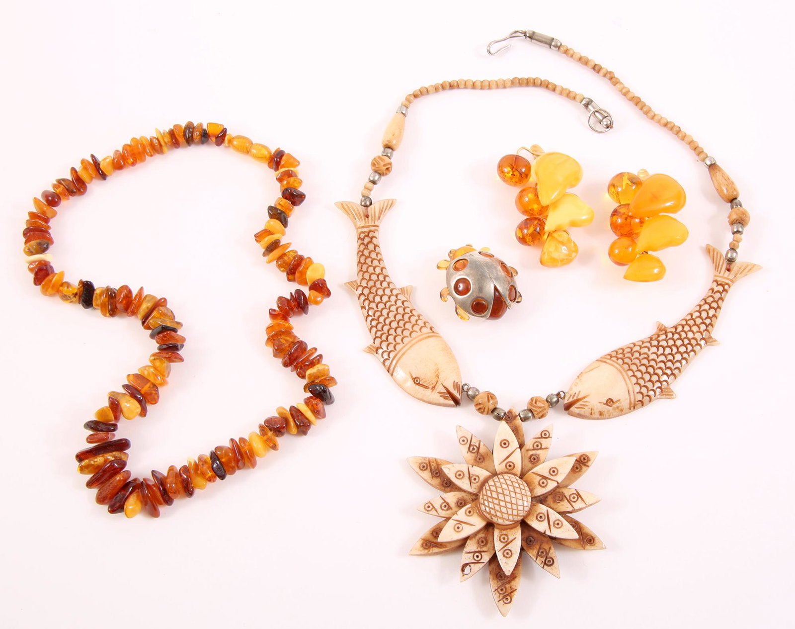 AMBER AND BEADED NECKLACES AND BROOCHES - LOT OF 5: AMBER AND BEADED NECKLACES AND BROOCHES - LOT OF 5 Lot of 5 amber and beaded necklaces and brooches, including: Tan beaded necklace with fish and flower design, 20 1/4 inches long, Amber beaded neckla