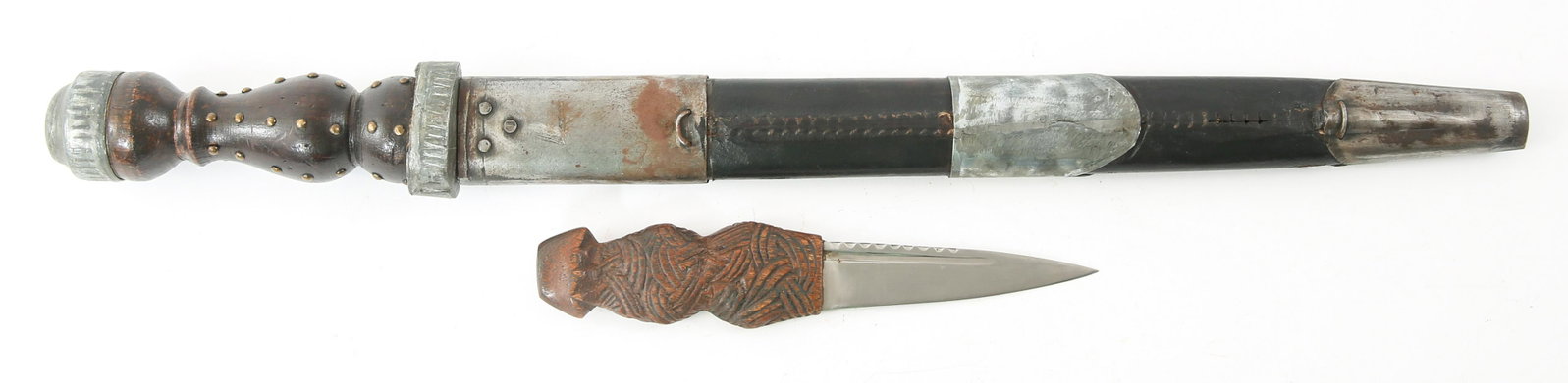 SCOTTISH DIRK DAGGERS - LOT OF 2: SCOTTISH DIRK DAGGERS - LOT OF 2 Lot of two Scottish dirk daggers, includes small 7.25" dirk with carved wooden handle and 15" dagger with wood and hobnail design handle, leather and white metal scabb
