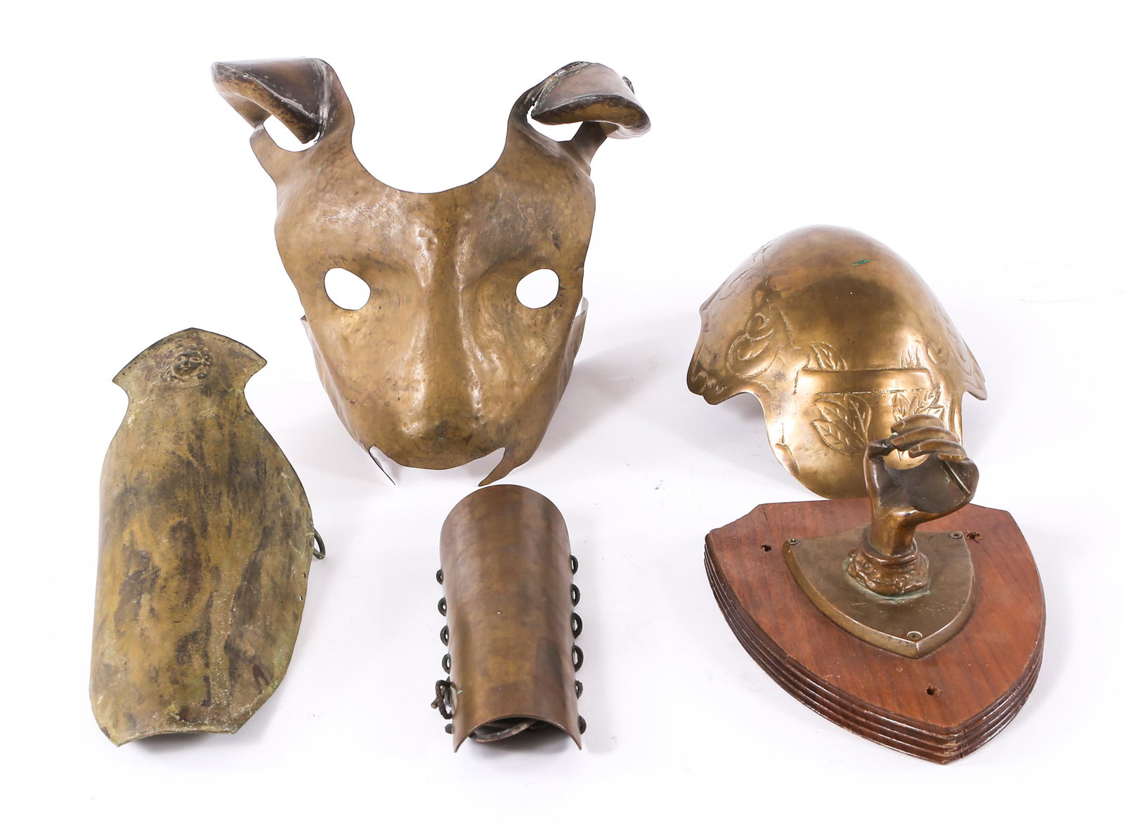 BRASS ARMOR PIECES & SCONCE - LOT OF 5: BRASS ARMOR PIECES & SCONCE - LOT OF 5 Lot of brass armor guards and lion face visor, also includes one brass hand form sconce on wooden plaque, 6 x 7.5".