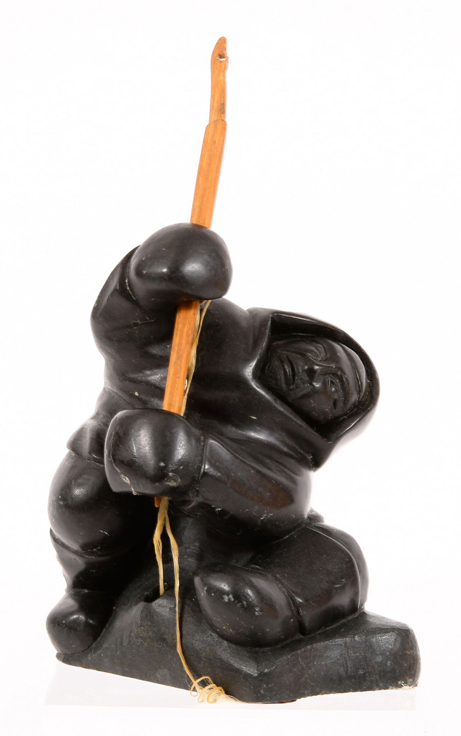 LUCASSIE ECHALOOK INUIT CARVED STONE SCULPTURE: LUCASSIE ECHALOOK INUIT CARVED STONE SCULPTURE Lucassie Echalook (Inuit, b. 1942) carved stone sculpture of an ice fisherman pulling in his catch, signed "Echaluk" on underside, circa 1970's. Size: 8"