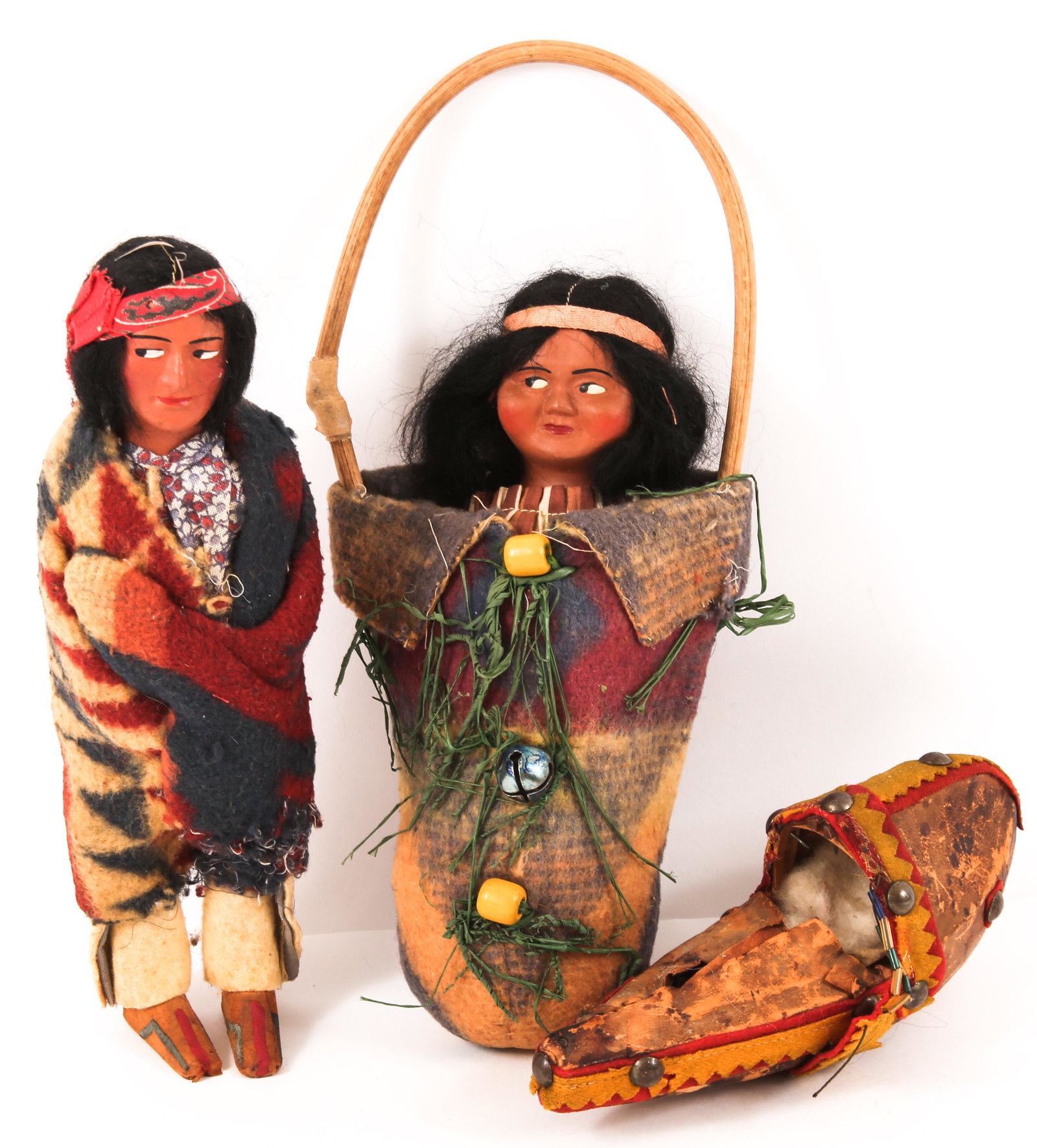 SKOOKUM DOLLS & MINIATURE CRADLEBOARD - LOT OF 3: SKOOKUM DOLLS & MINIATURE CRADLEBOARD - LOT OF 3 Lot of three, includes: Skookum dolls, man and woman 9" and 10" Miniature cradleboard, made of brain tanned deer hide. 7.5" <