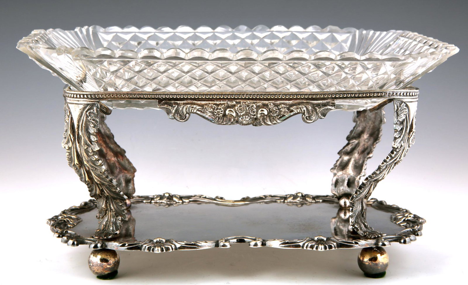 G.F. HAMILTON SILVER PLATE AND CUT GLASS SERVING TRAY: G.F. HAMILTON SILVER PLATE AND CUT GLASS SERVING TRAY Marked G.F. Hamilton Scottish facet cut glass serving tray with silver plated stand. Numbered 5096. Size: 12 x 9 x 6.5". Size: 12 x 9 x 6.5"