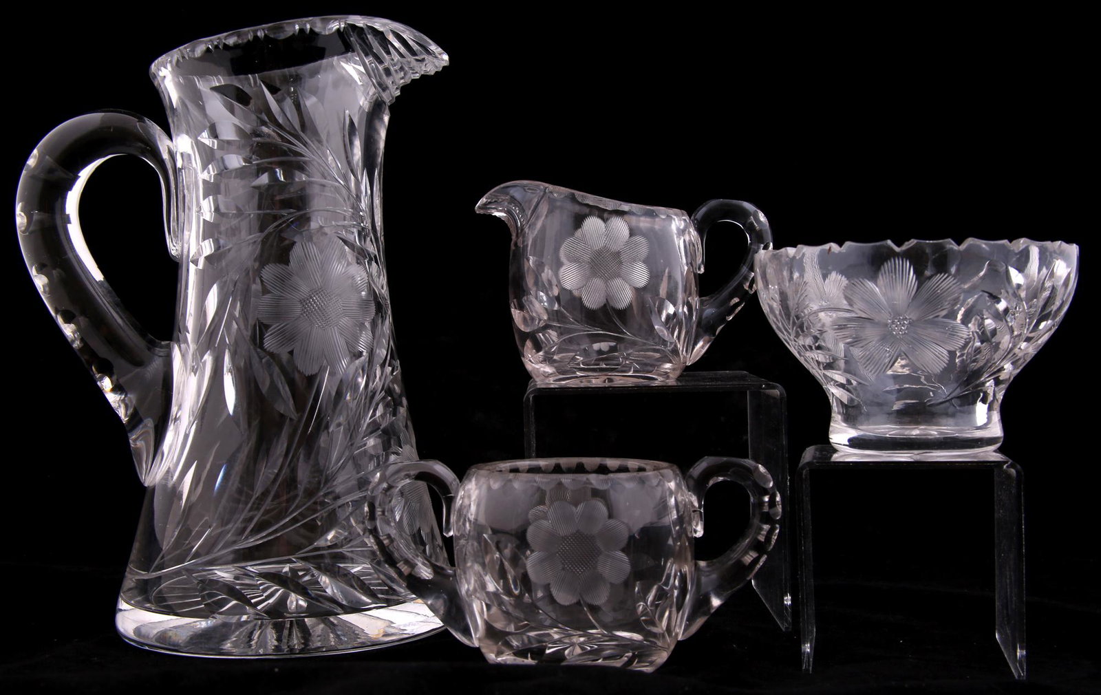 FLORAL CUT GLASS SERVEWARE - LOT OF 4: FLORAL CUT GLASS SERVEWARE - LOT OF 4 Lot of 4 cut glass serveware with floral designs. Includes: Pitcher. Height: 10". Diameter: 5.5". Creamer. Height: 3.5". Diameter: 2.75". Small bowl. Height: 3".