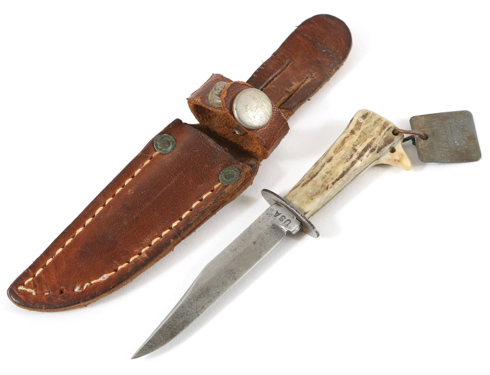 MINIATURE ANTLER FIXED BLADE KNIFE WITH SHEATH: MINIATURE ANTLER FIXED BLADE KNIFE WITH SHEATH Miniature hunting knife stamped "USA" on tang, antler handle, with tag stamped "WIS TRAP 42-43". Blade is approximately 2", includes leather sheath. Size