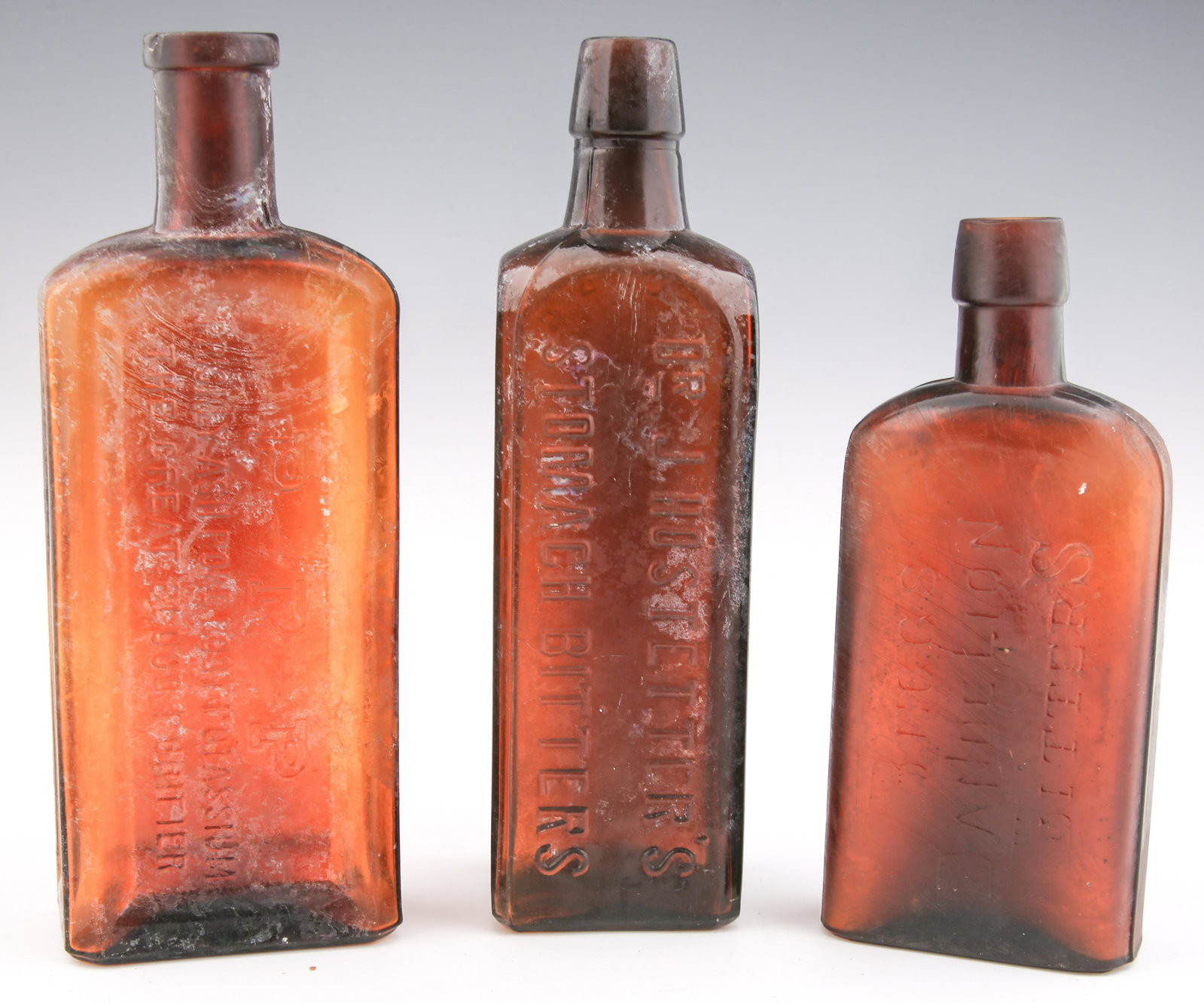 LATE 19TH C. GLASS BITTERS BOTTLES - LOT OF 3: LATE 19TH C. GLASS BITTERS BOTTLES - LOT OF 3 Lot of 3 late 19th century glass bitters bottles. Includes: Marked Dr. J. Hostetter's Stomach Bitters bottle. Measures 2.5 x 2.5 x 9". Marked Begg's Da