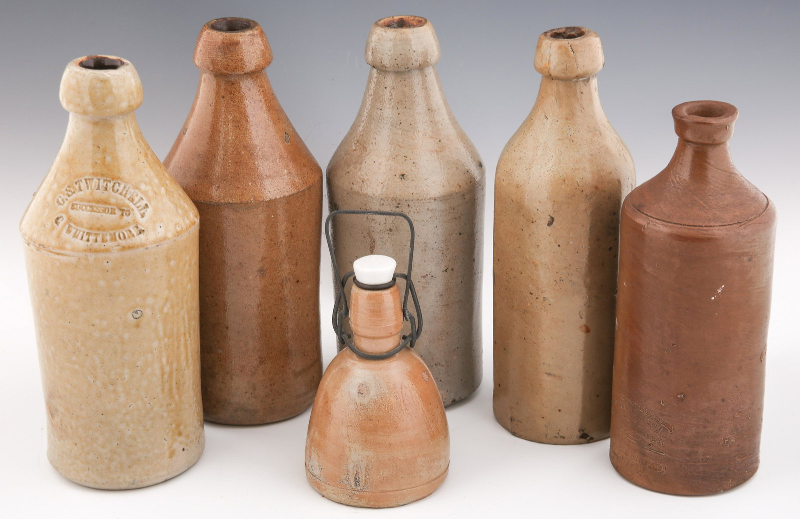 STONEWARE BOTTLES - LOT OF 6: STONEWARE BOTTLES - LOT OF 6 Lot of 6 stoneware bottles. Includes: Bourne & Son bottle. Stamped "J. Bourne & Son Patentees Denry Pottery Near Derby P & J Arnold London." Measures 9" tall a