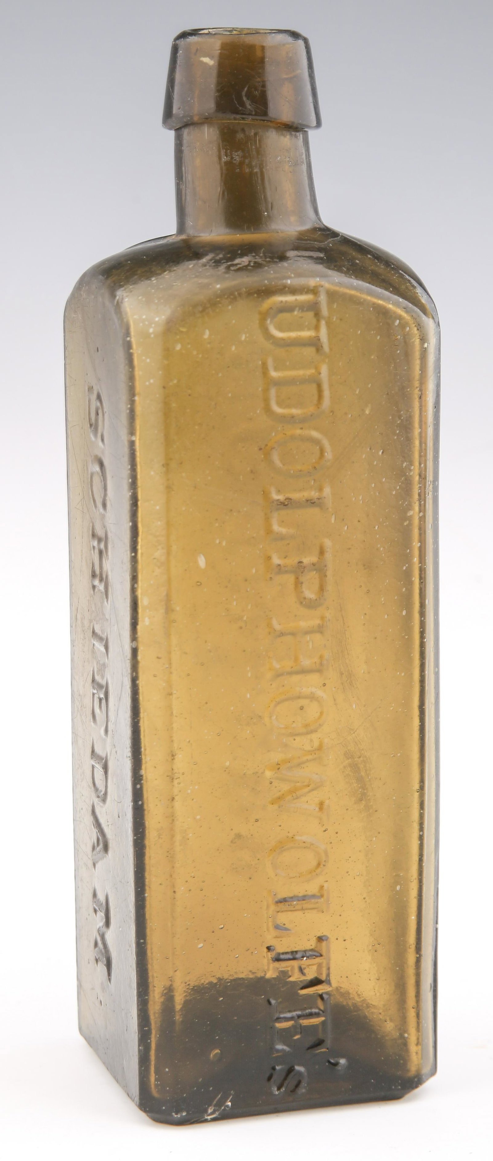 GREEN UDOLPHO WOLFE'S AROMATIC SCHNAPPS BOTTLE: GREEN UDOLPHO WOLFE'S AROMATIC SCHNAPPS BOTTLE Green Udolpho Wolfe's Schiedam Aromatic Schnapps bottle. Measures 8" tall and 2.25" square. Size: 2.25 x 8"