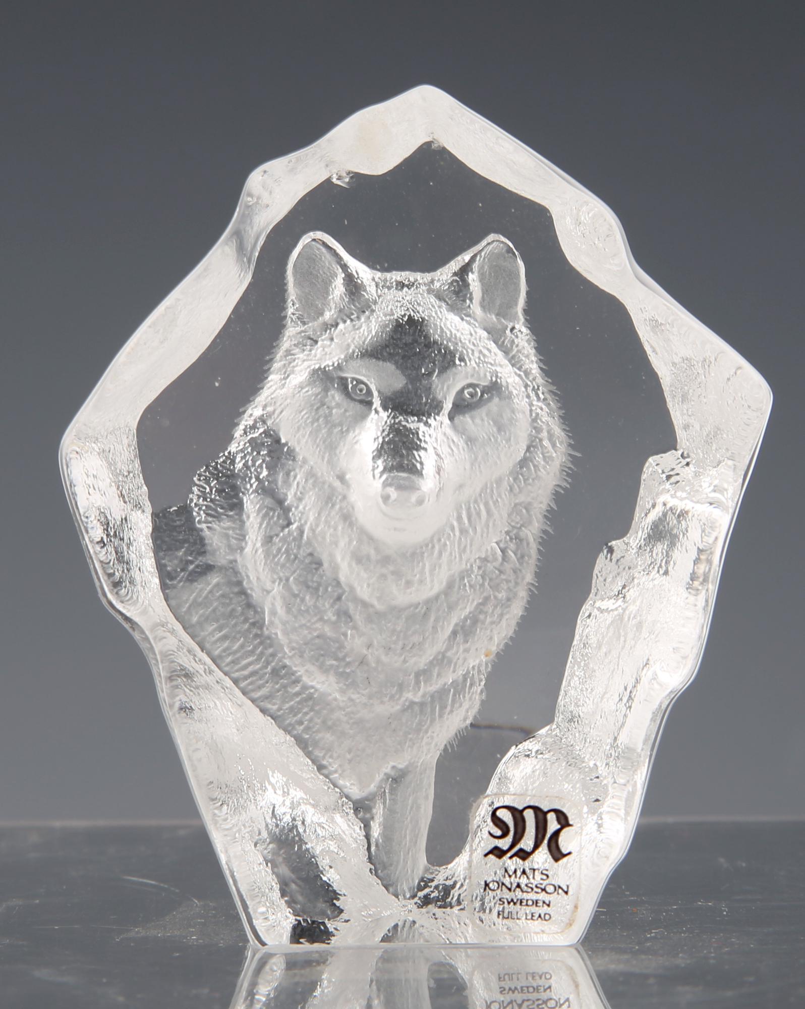 MATS JONASSON CRYSTAL ART GLASS WOLF SCULPTURE: MATS JONASSON CRYSTAL ART GLASS WOLF SCULPTURE Mats Jonasson Sweden crystal art glass wolf sculpture. Size approximately 2.25 x 1 x 2.5". Artist sticker at the front, bottom right. Size: 2.25 x 1 x 2.