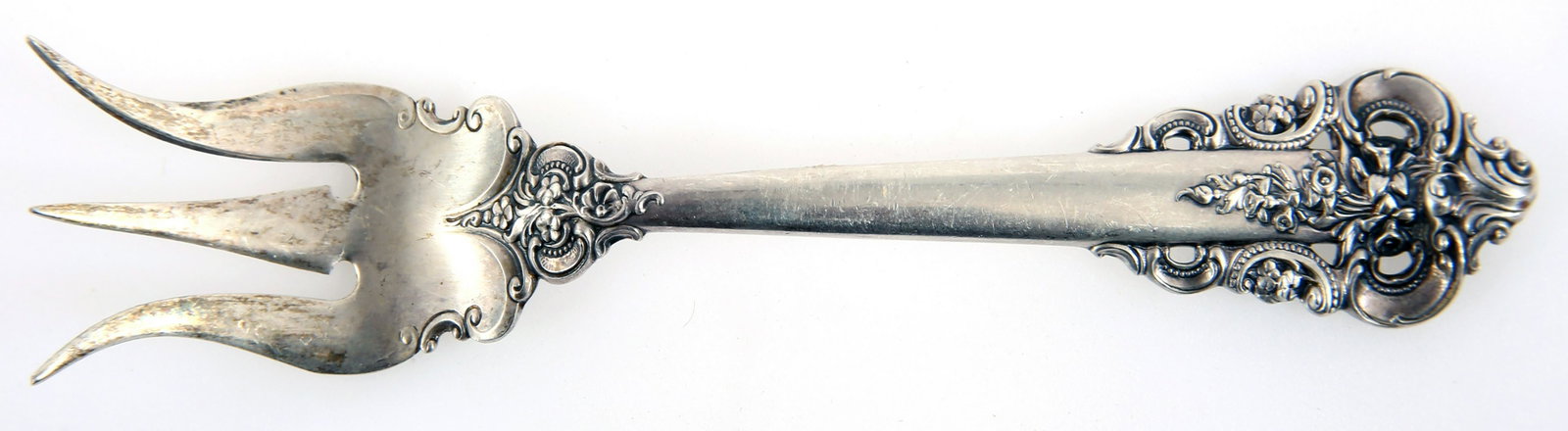 WALLACE STERLING SILVER GRANDE BAROQUE LEMON FORK: WALLACE STERLING SILVER GRANDE BAROQUE LEMON FORK Wallace sterling silver lemon fork, in the Grande Baroque pattern. Size: 5.6" Weight: 28.8g