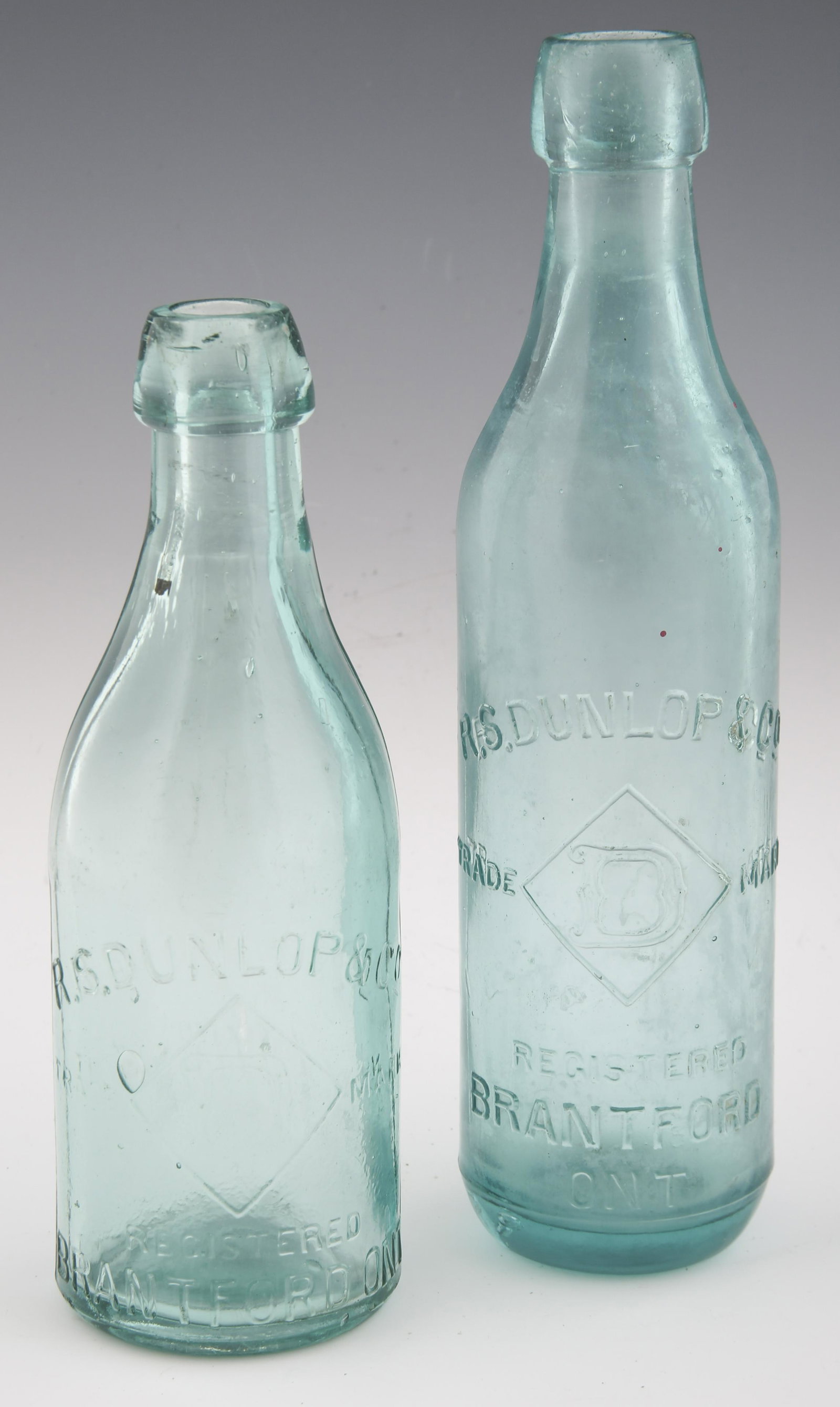 R.S. DUNLOP & CO. CANADIAN GLASS BOTTLES - LOT OF 2: R.S. DUNLOP & CO. CANADIAN GLASS BOTTLES - LOT OF 2 Lot of 2 R.S. Dunlop & Co. Canadian glass bottles. Both marked "R.S. Dunlop & Co. Trade Mark D Registered Brantford ONT." Sizes include: 9.5
