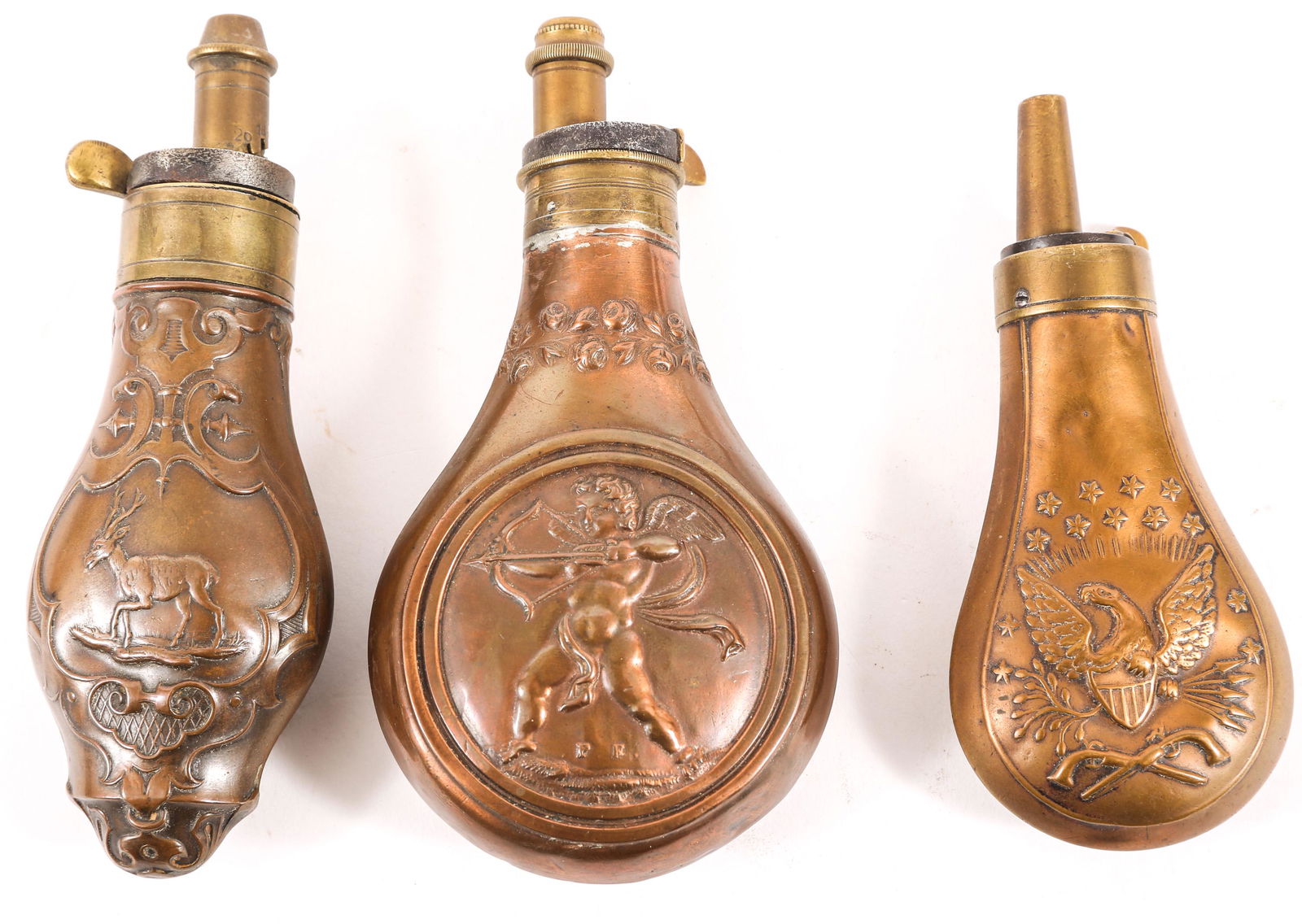 19TH C. EUROPEAN & AMERICAN POWDER FLASKS LOT OF THREE: 19TH C. EUROPEAN & AMERICAN POWDER FLASKS LOT OF THREE Lot of three 19th C. American and European powder flasks, including: Deer scene, 4.75" Cupid scene, 4.5" American eagle scene, 4"