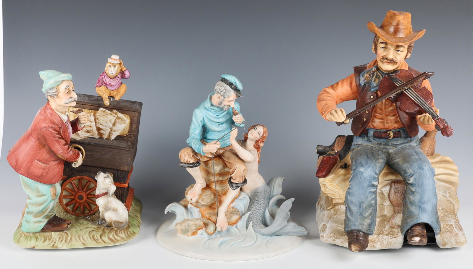 PORCELAIN FIGURINES - LOT OF 3: PORCELAIN FIGURINES - LOT OF 3 Porcelain figurines to include: Melody in motion, "The Fiddler", #07014, 11.5" Melody in motion, "Organ Grinder", #07053, 9.5" Pucci, "Areal Catch", #3730, 9.3" <