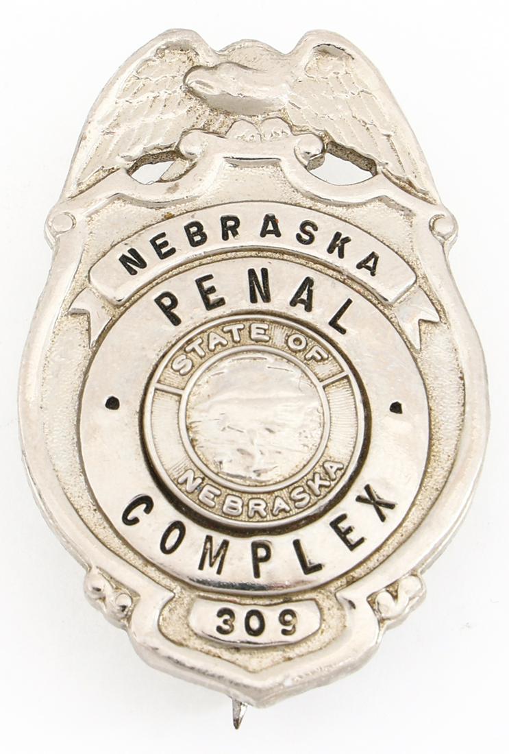 NEBRASKA PENAL COMPLEX BADGE NO. 309: NEBRASKA PENAL COMPLEX BADGE NO. 309 Obsolete Nebraska Penal Complex badge. Numbered 308. Marked GEORGE F. CAKE CO. BERKELEY, CAL on reverse. Measurements: 1.75 X 1"