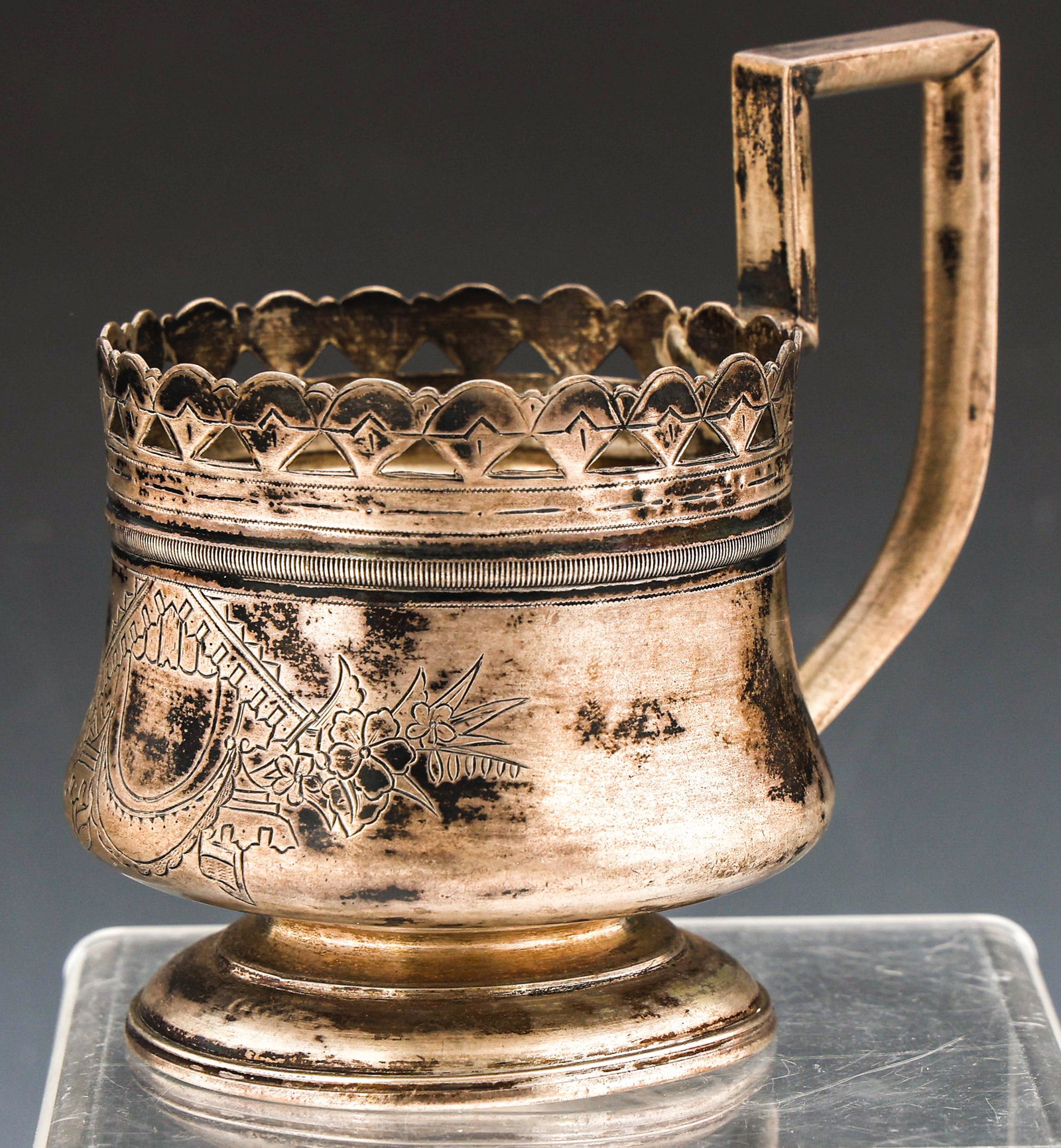 1888 RUSSIAN 84 SILVER TEA GLASS HOLDER: 1888 RUSSIAN 84 SILVER TEA GLASS HOLDER Russian 84 zolotnik (.875 fineness) silver tea glass holder, dated 1888, decorated with engraved vignette and pierced rim. Marked on underside. Size: 3 3/4 x 4 