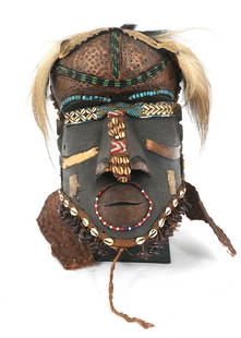 AFRICAN CONGO KUBA BWOOM HELMET MASK: AFRICAN CONGO KUBA BWOOM HELMET MASK African Congo Kuba carved wood Bwoom helmet mask, 20th century. Decorated with various shells, beads, seed pods, metal appliques, and fur. Size: 14 x 9 x 10"