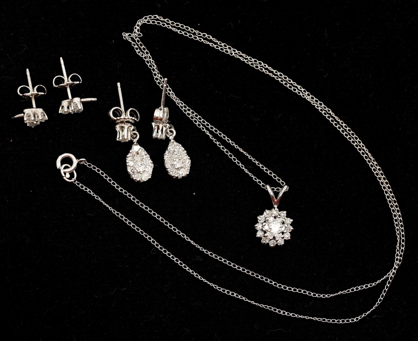 14K WHITE GOLD DIAMOND EARRINGS & NECKLACE: 14K WHITE GOLD DIAMOND EARRINGS & NECKLACE 14K white gold diamond earrings and necklace, include: Floral design earrings - 0.24 ctw Each has (3) 0.04 ct round white diamonds Teardrop cluster earring