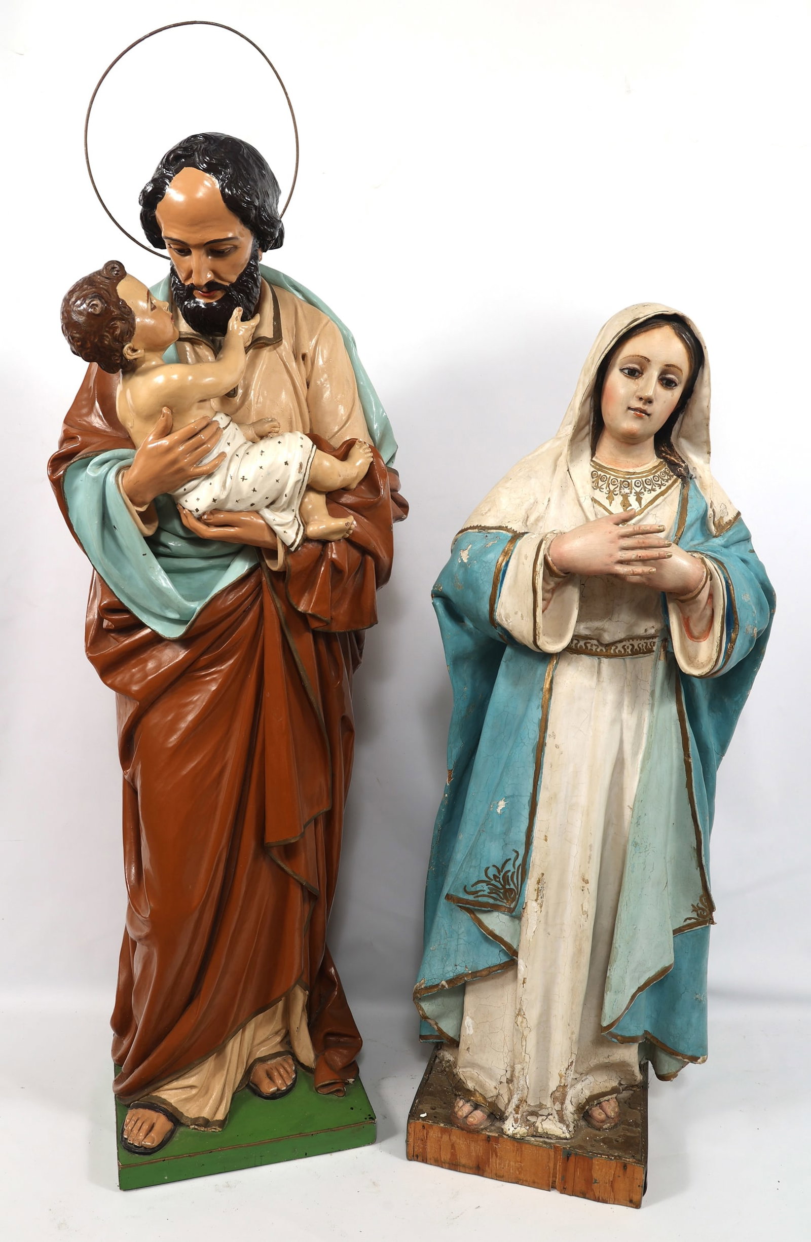 20TH C. WOOD & PLASTER HOLY FAMILY STATUES: 20TH C. WOOD & PLASTER HOLY FAMILY STATUES 20th century Holy Family statues include: Carved and painted wooden statue of Joseph holding the Christ child, 45" Plaster and carved wooden statue of the