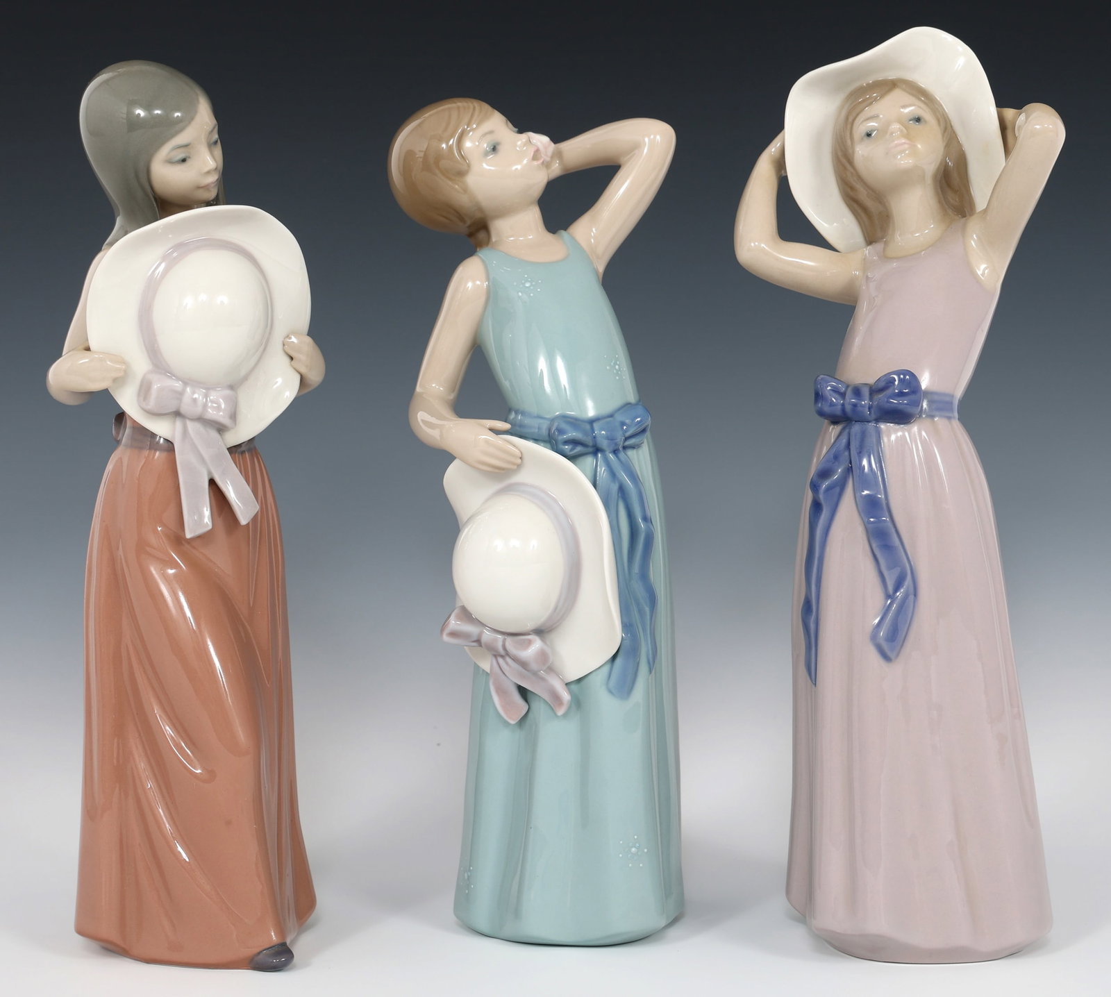 LLADRO PORCELAIN FIGURINES 5007, 5010, & 5011: LLADRO PORCELAIN FIGURINES 5007, 5010, & 5011 Three Lladro porcelain figurines including: "Bashful" #5007, 10" "Prissy Couffure" #5010, 9.5" "Trying on Straw Hat" #50