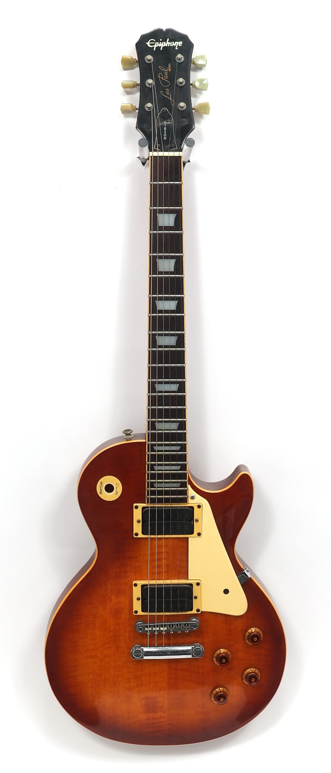 EPIPHONE LES PAUL ELECTRIC GUITAR: EPIPHONE LES PAUL ELECTRIC GUITAR Epiphone Les Paul electric guitar. Tobacco burst body, cream pickguard. Body: Solid Includes Case: No Model: Les Paul Overall Length: 39.25" Serial Number: U6051727 W