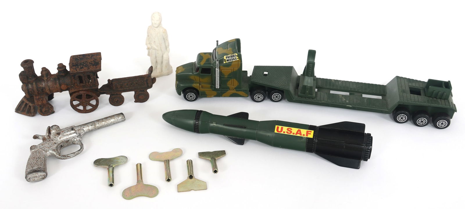 NOVELTY TOYS AND CLOCK KEYS: NOVELTY TOYS AND CLOCK KEYSNovelty US Air Force Missile Transport, King mini cap gun, cast iron train, bisque ceramic figurine, and clock keys.