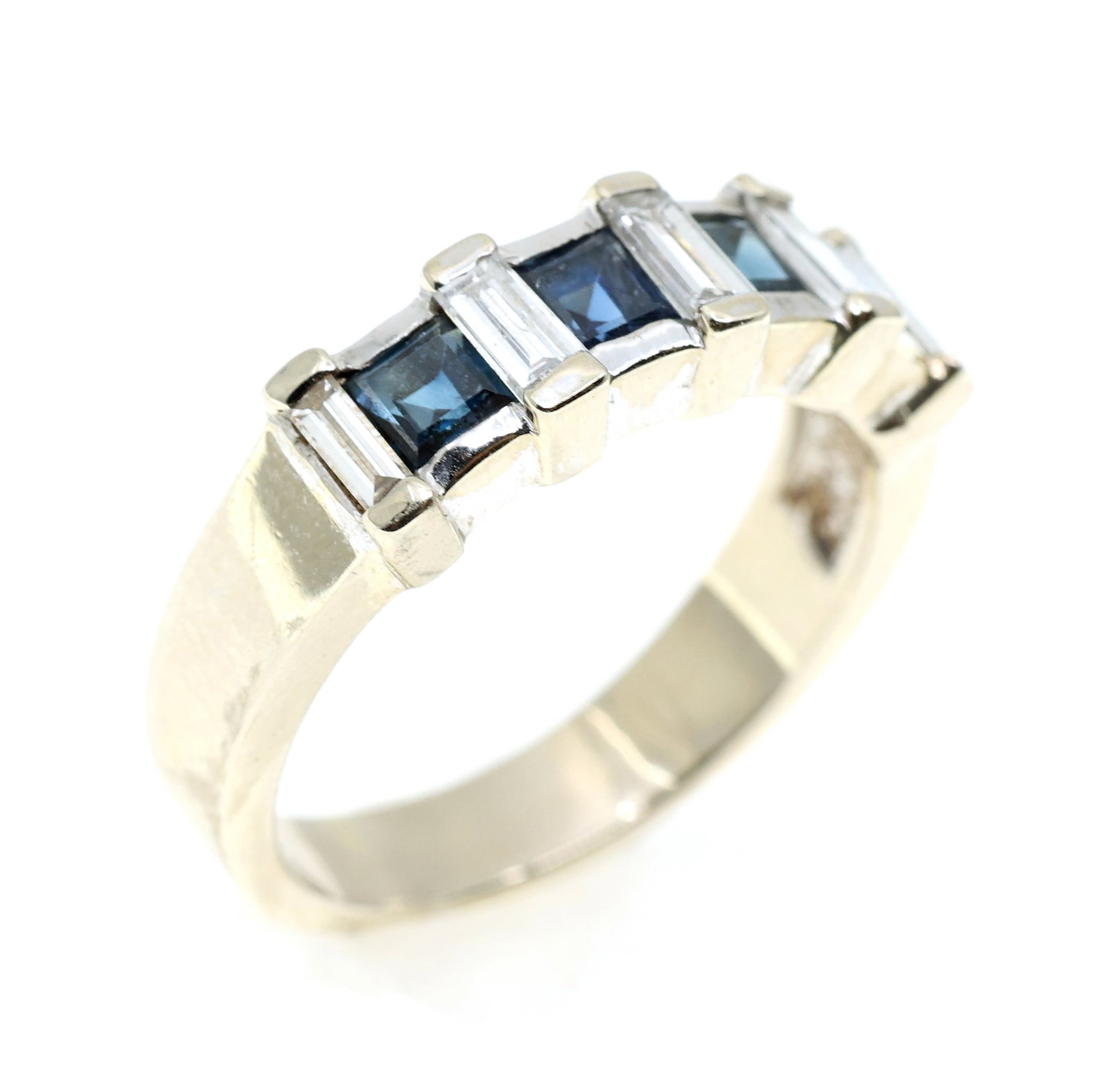 14K WHITE GOLD SAPPHIRE & DIAMOND BAND: 14K WHITE GOLD SAPPHIRE & DIAMOND BAND 14K white gold fashion band with: (4) Blue sapphire Princess cut 2.5 x 2.5mm (5) 0.065 ct baguette diamonds <