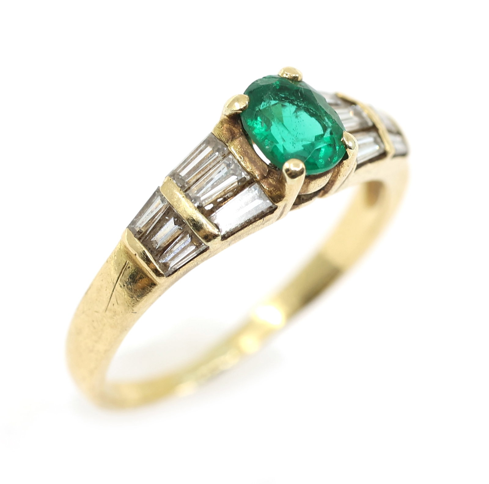 18K YELLOW GOLD EMERALD & DIAMOND FASHION RING: 18K YELLOW GOLD EMERALD & DIAMOND FASHION RING 18K yellow gold fashion ring: Emerald (1) 5.5 x 4.5mm oval cut Diamonds (6) 0.05 ct tapered baguett
