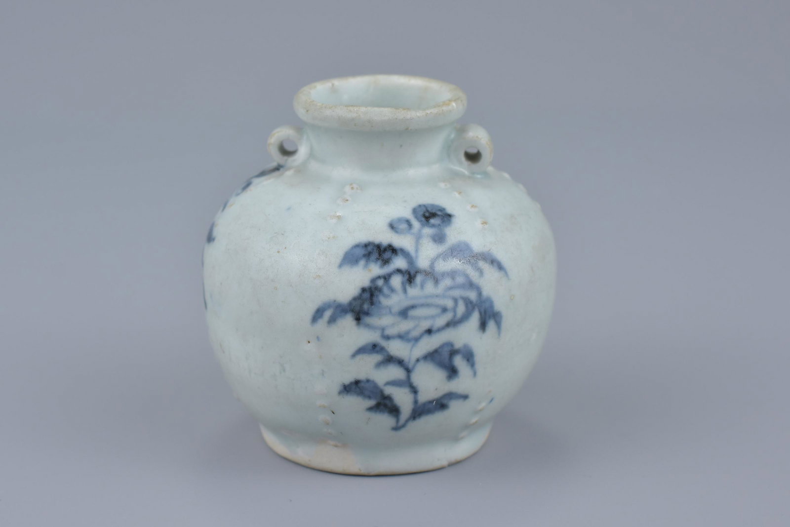 A Chinese Yuan dynasty blue and white jarlet: A Chinese Yuan dynasty (1279-1368) blue and white porcelain jarlet with twin looped handles and lines of vertically arranged studs. 7Cm tall. Provenance: Purchased in 1977 from Hugh Moss Limited, Lond