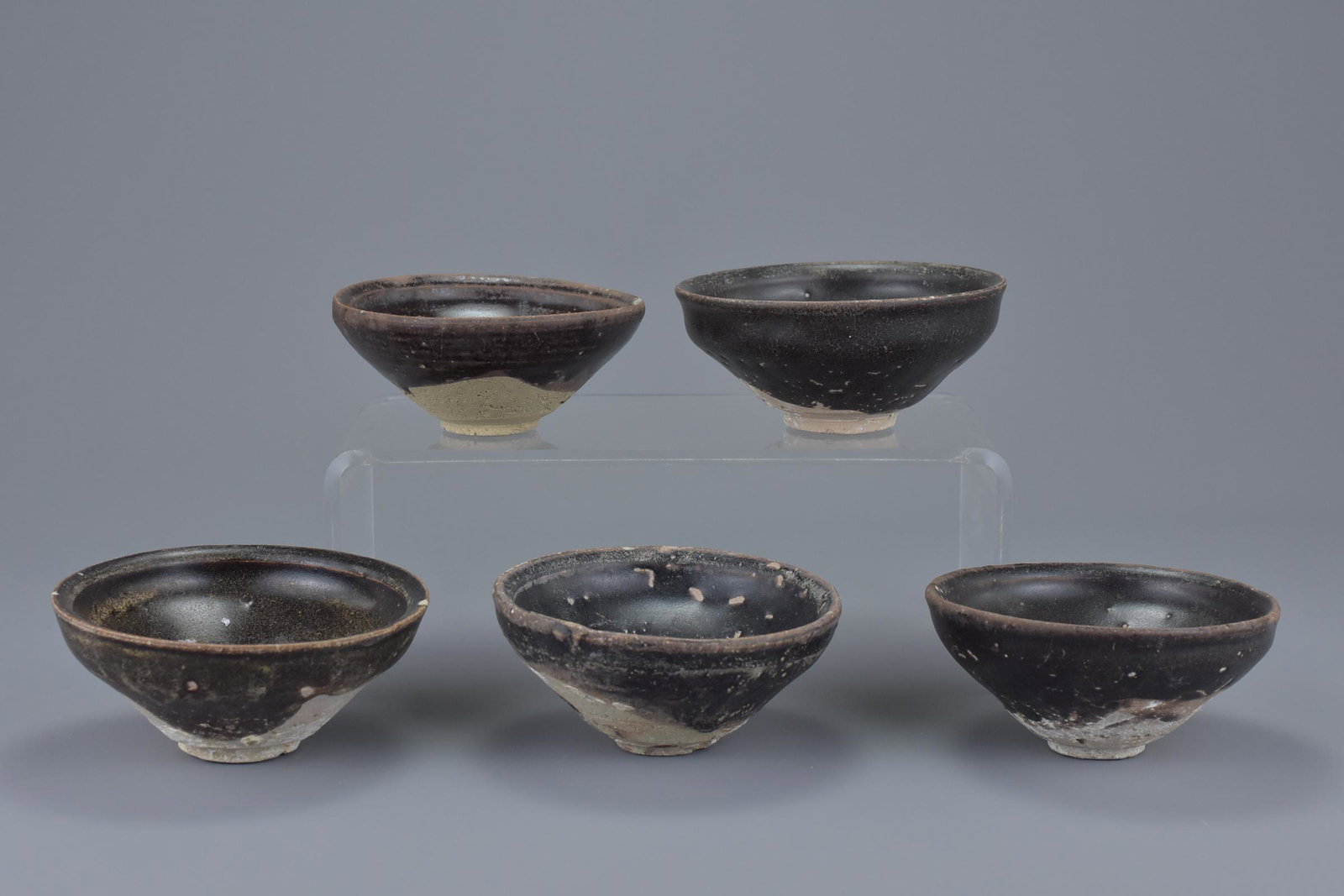 A group of five Chinese Song dynasty (960-1279) black: A group of five Chinese Song dynasty (960-1279) black glazed pottery tea bowls. 10Cm diam.