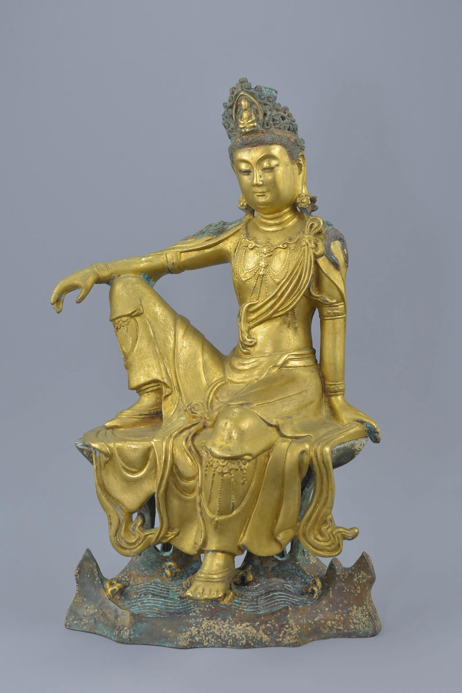 A Chinese gilt bronze figure of Guanyin seated on a (1 of 4)