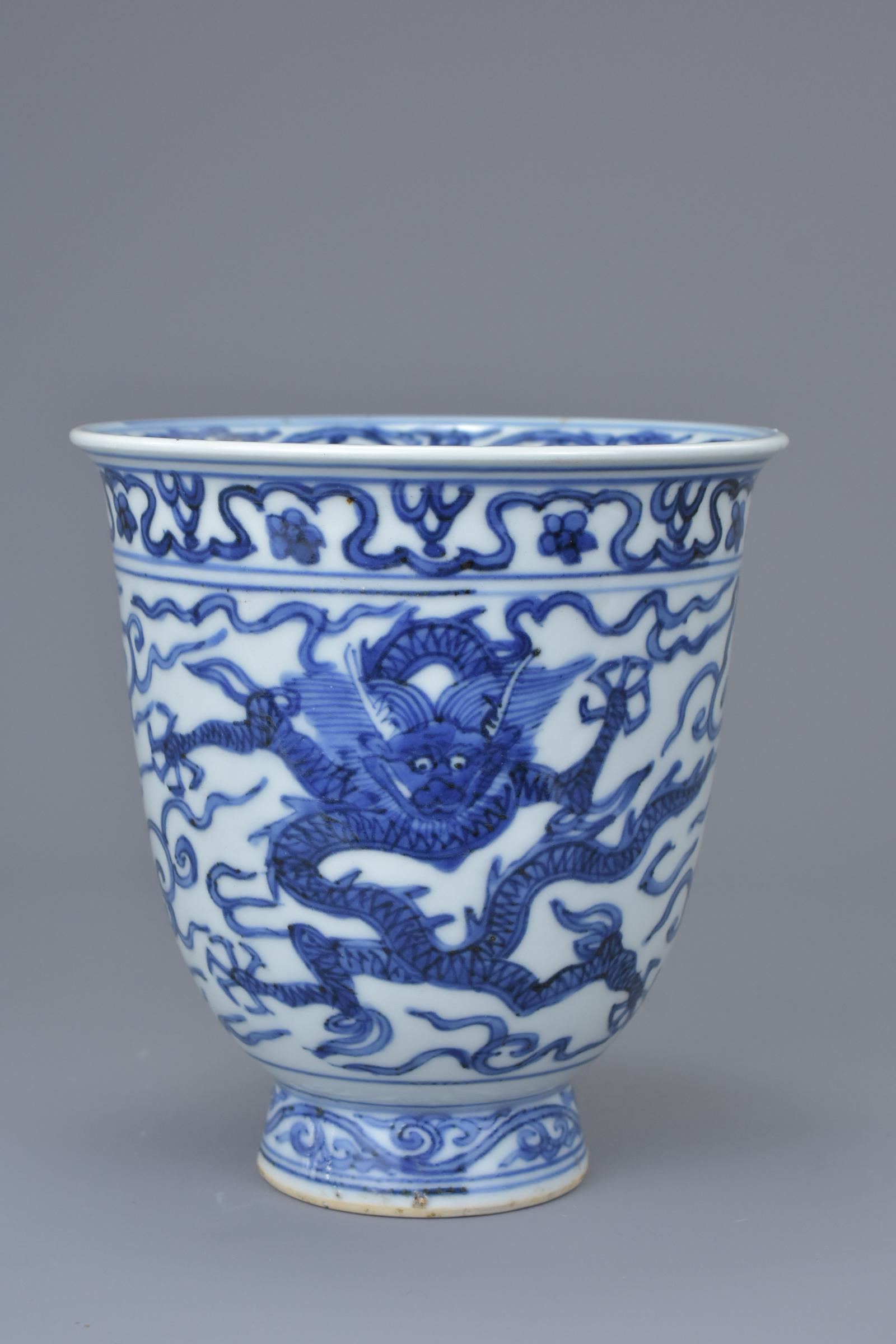A Chinese Ming Dynasty or later blue and white: A Chinese Ming Dynasty or later blue and white porcelain dragon beaker with six character mark of Wanli to base - Possibly of the period. 13cm tall x 12.5cm diameter