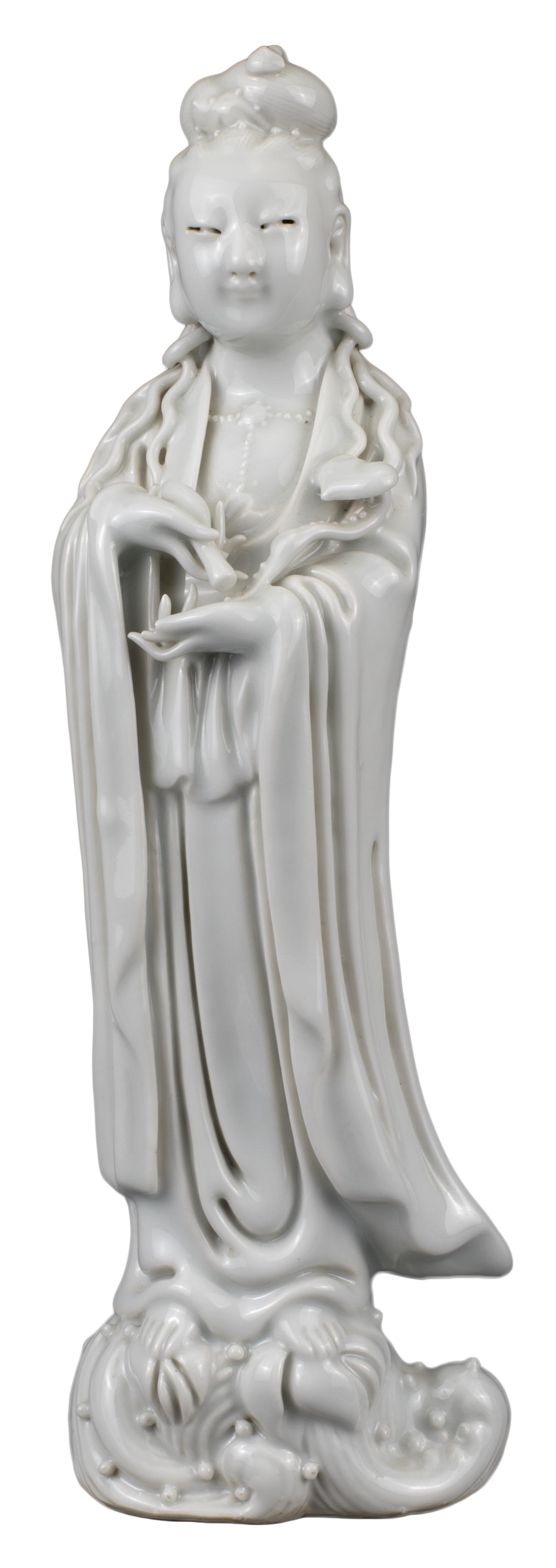 CHINESE BLANC DE CHINE PORCELAIN FIGURE OF GUANYIN,: CHINESE BLANC DE CHINE PORCELAIN FIGURE OF GUANYIN, QING DYNASTY Standing on reeds, dressed in robes holding a ruyi sceptre and bottle. 19th Century. 25cm tall Provenance: Alexander E Grace Collection