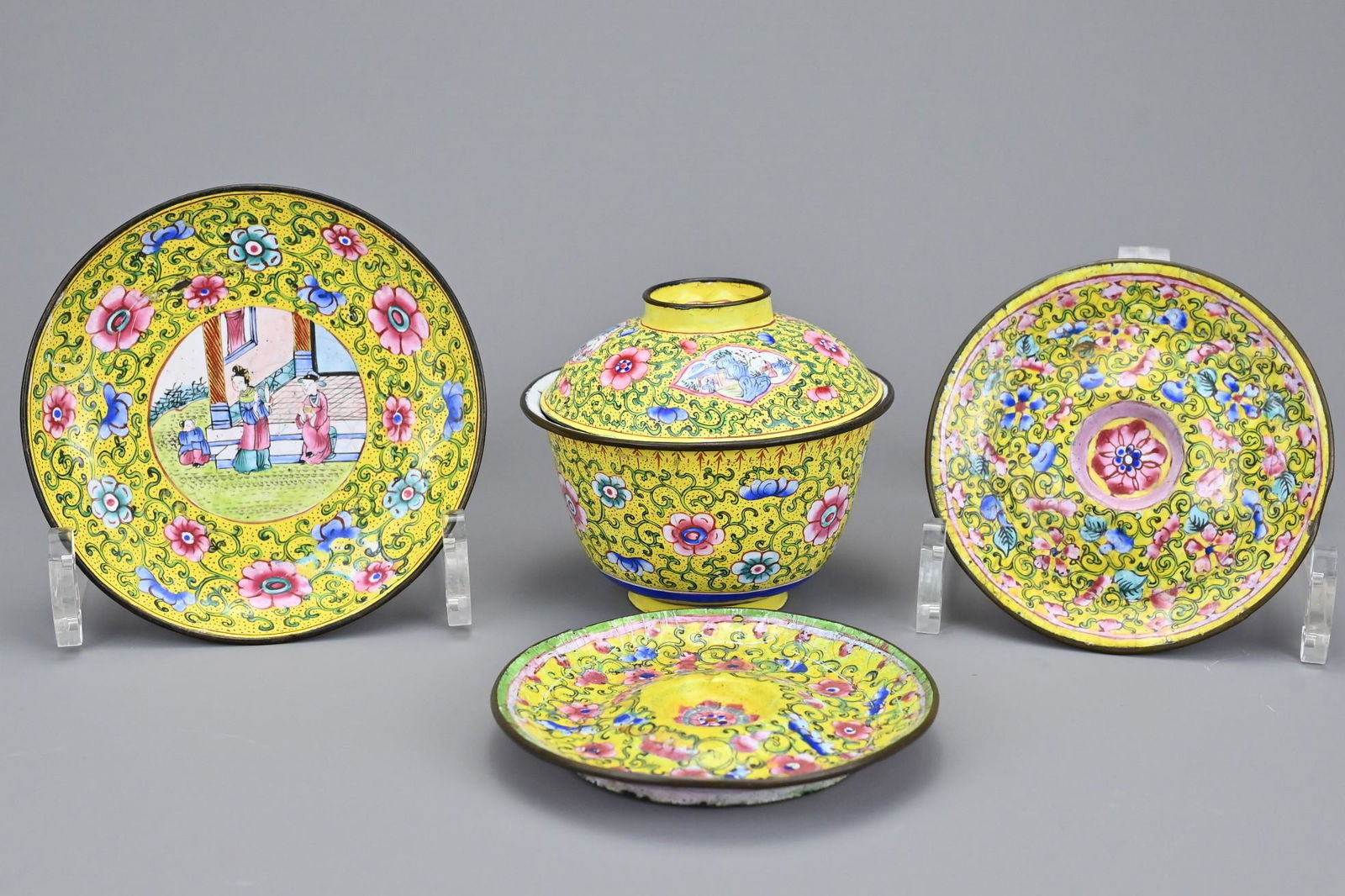 A group of Chinese Canton enamelled items to include a: A group of Chinese Canton enamelled items to include a cup and cover with matching saucer. Together with a pair of saucers. Tea cup on saucer approx. 9cm tall (5)Area of loss to cup showing the copper