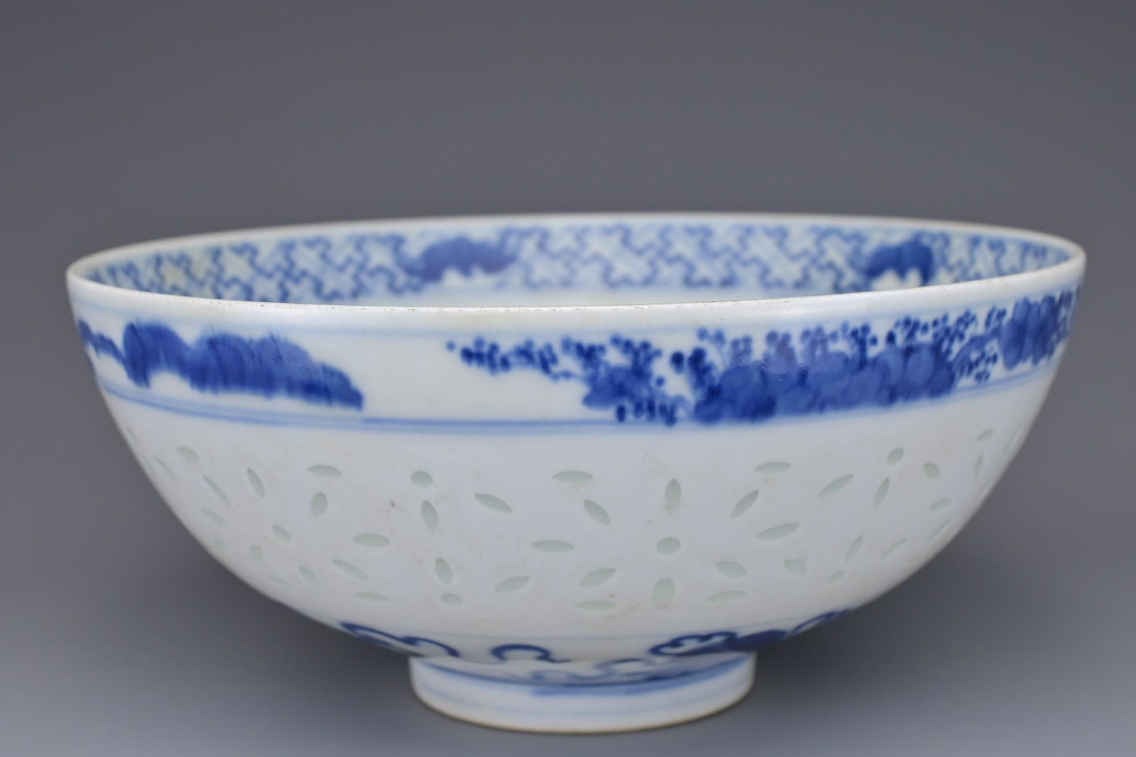 A CHINESE BLUE AND WHITE 'RICE GRAIN' PORCELAIN BOWL: A CHINESE BLUE AND WHITE 'RICE GRAIN' PORCELAIN BOWL. Decorated with band of translucent rice grain pattern between bands of auspicious symbols and foliage. Six-character mark of Guangxu to base. 17.2