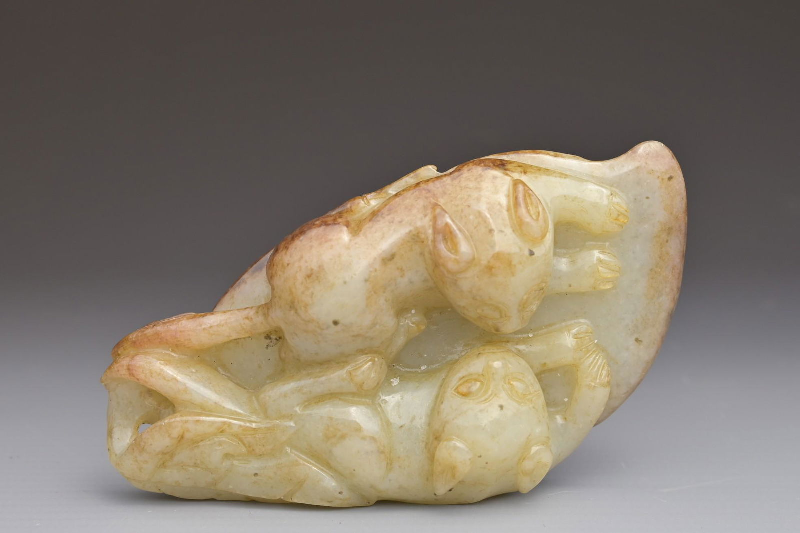 A CHINESE CELADON AND RUSSET JADE PENDANT OF TWO CATS ON A LEAF (1 of 6)