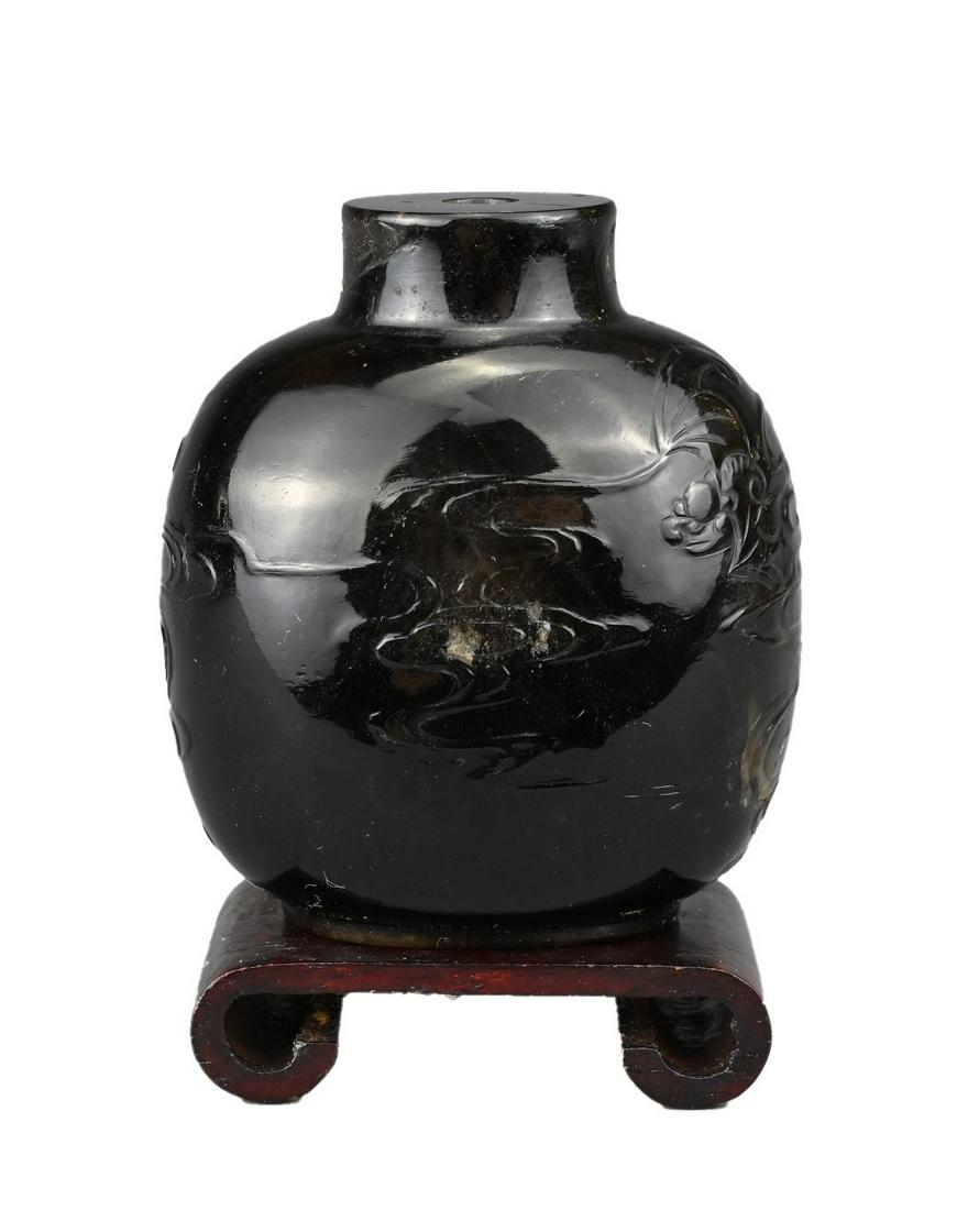 A CHINESE PEKING GLASS SNUFF BOTTLE, QING DYNASTY. Carved in shallow relief with bats and clouds. (1 of 8)