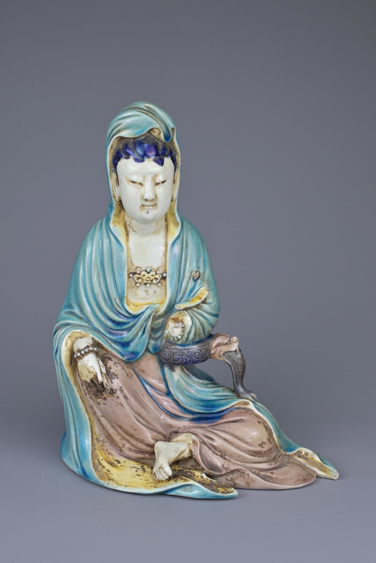 A CHINESE PORCELAIN FIGURE OF GUANYIN, 19TH CENTURY. Glazed figure seated with four-character mark (1 of 9)