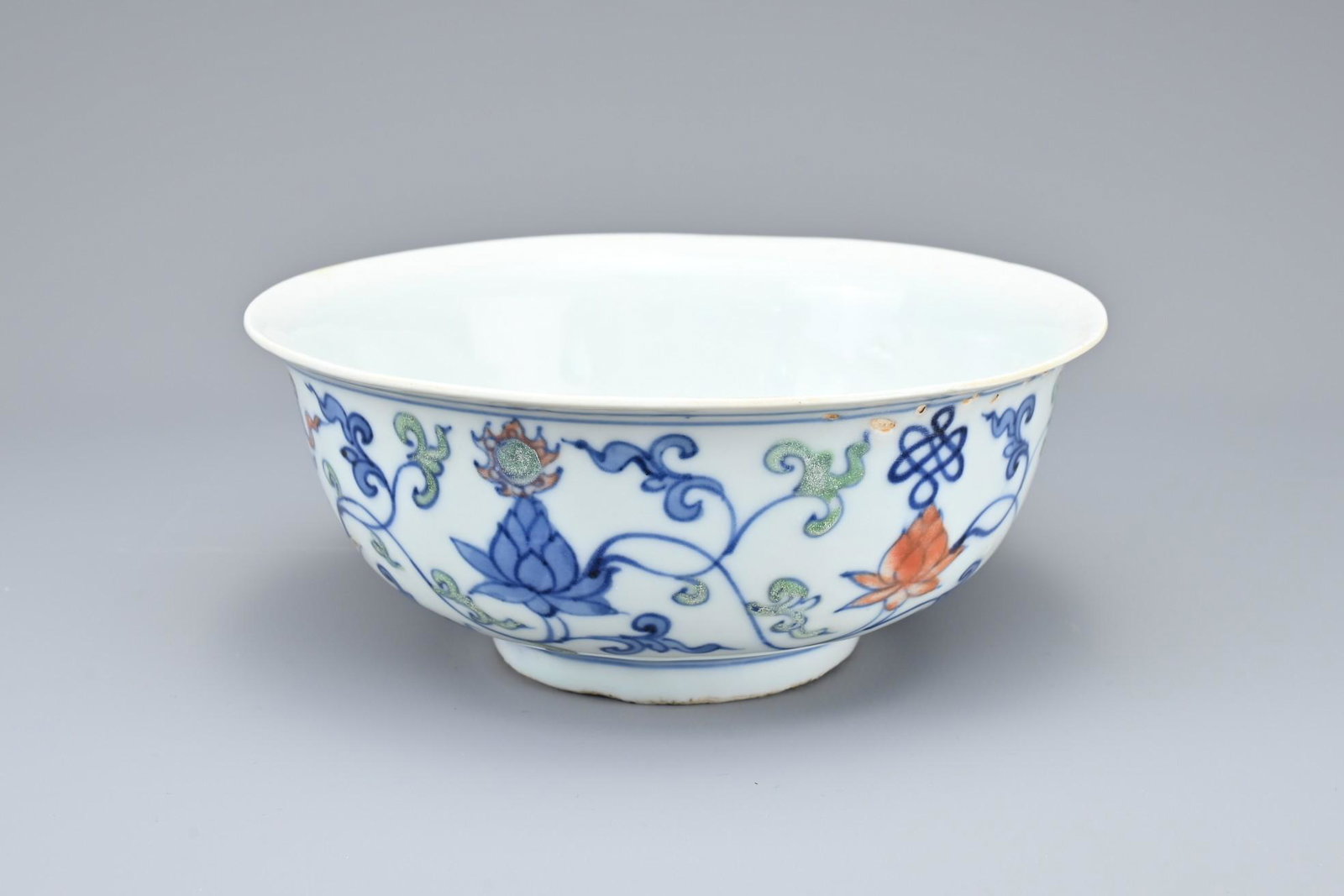 A CHINESE WUCAI PORCELAIN BOWL: A CHINESE WUCAI PORCELAIN BOWL. Rounded body with everted rim decorated in underglaze blue and enamel with Buddhist emblems and chrysanthemum scrolls. Six-character mark on Wanli to base but possibly 