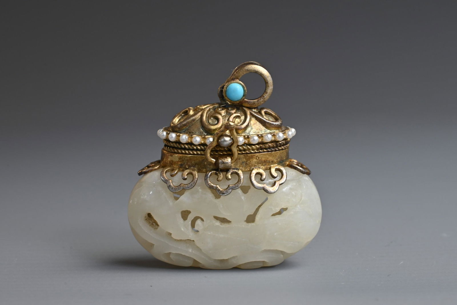A CHINESE CARVED PALE JADE, SILVER-GILT, TURQUOISE AND SEED PEARL MOUNTED PENDANT. The jade of (1 of 6)