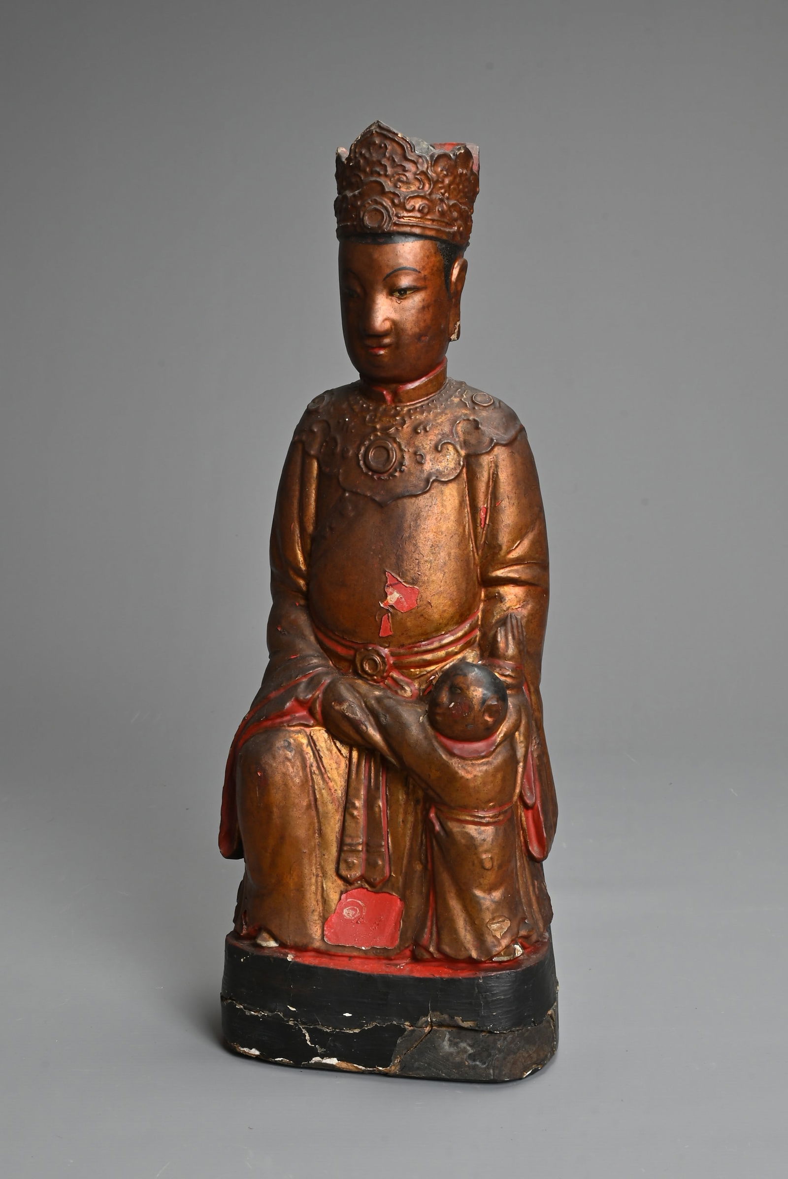 A CHINESE LACQUERED AND GILT WOOD FIGURE, MING DYNASTY. The figure seated dressed in robes with a: A CHINESE LACQUERED AND GILT WOOD FIGURE, MING DYNASTY. The figure seated dressed in robes with a boy at his left knee. 38cm tall.
