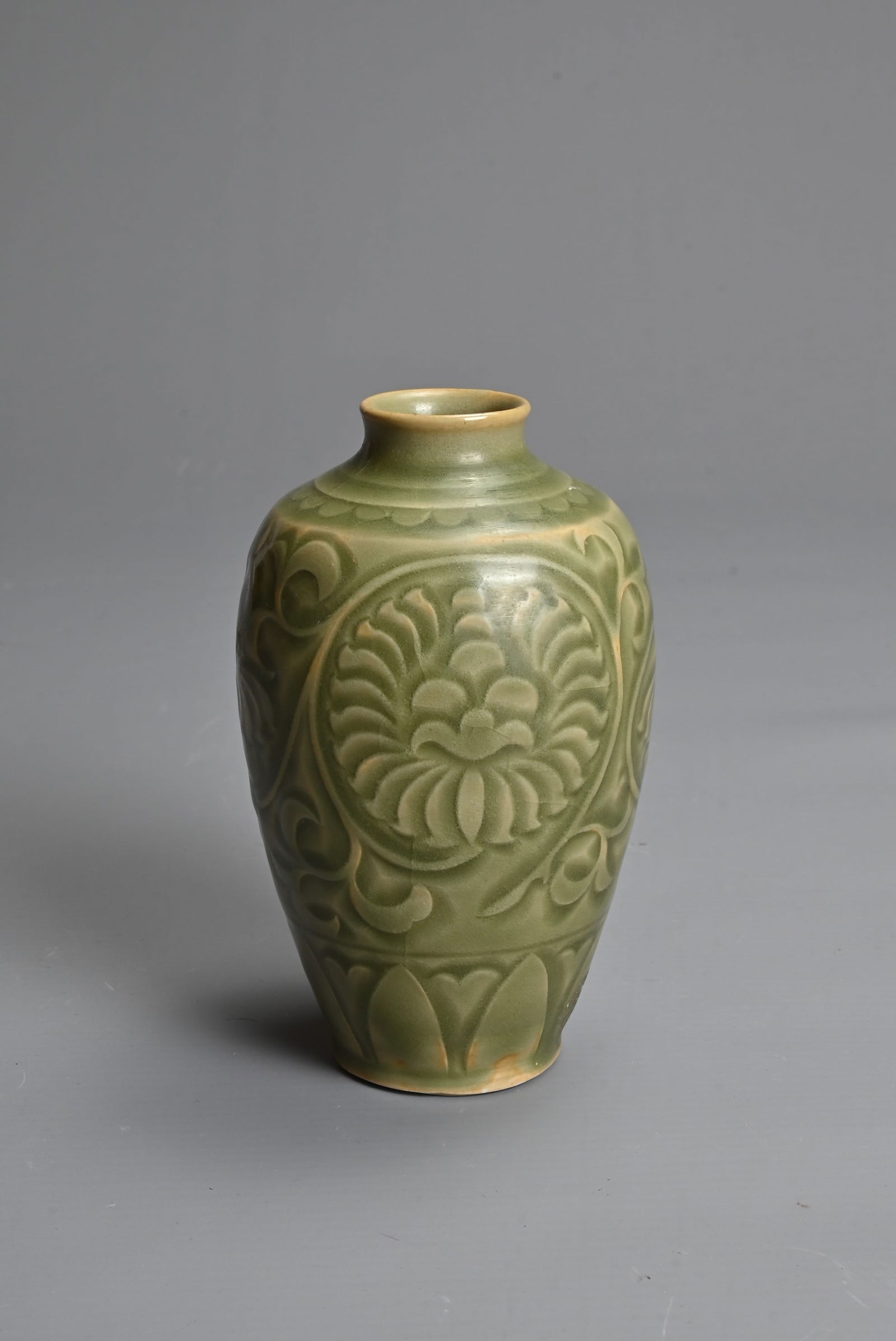A SMALL CHINESE CARVED YAOZHOU STYLE VASE. Finely potted carved with a lotus scrolls above a band of (1 of 6)