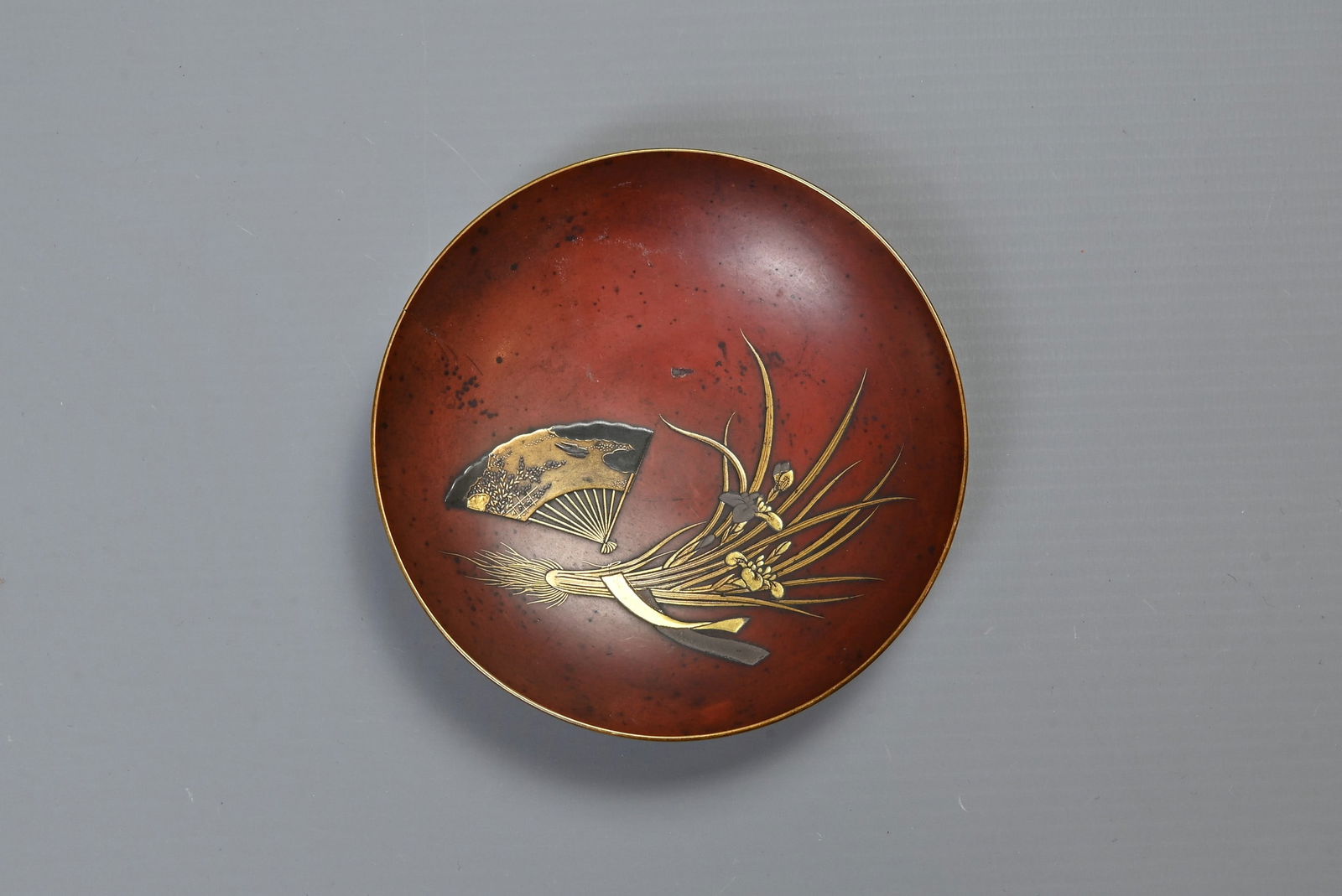 A JAPANESE MEIJI PERIOD (1868-1912) RED LACQUER SAKE CUP. Of circular shallow form, decorated in (1 of 5)