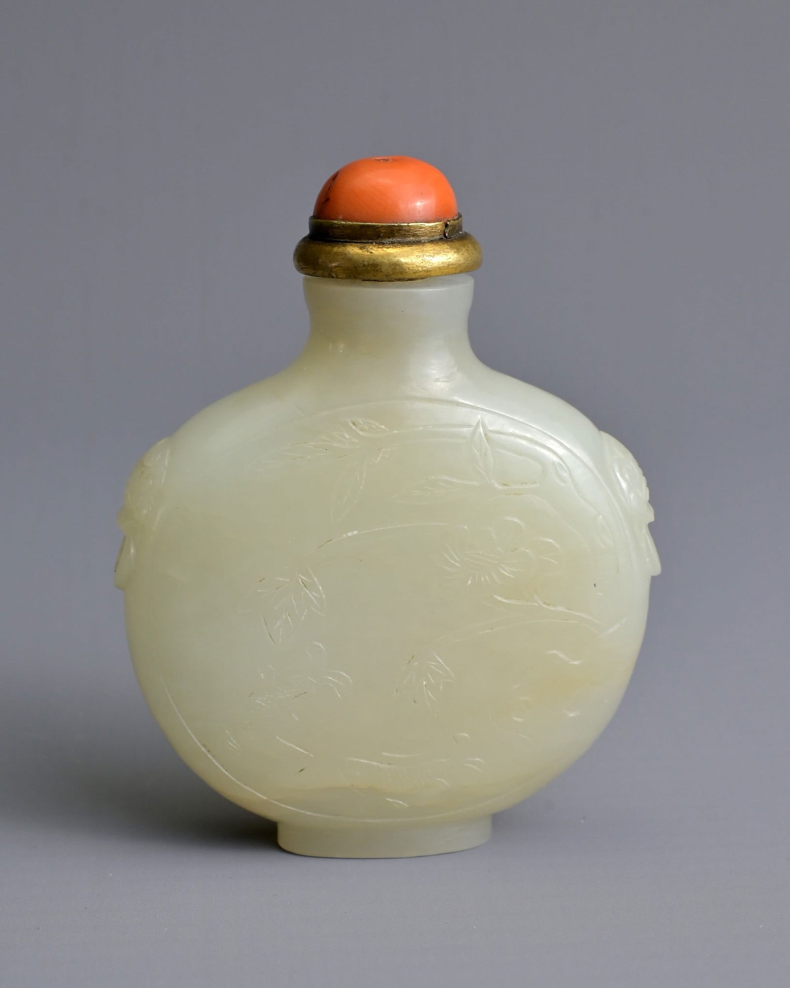A CHINESE PALE CELADON JADE SNUFF BOTTLE, 19/20TH CENTURY. Of flattened globular form carved in (1 of 9)