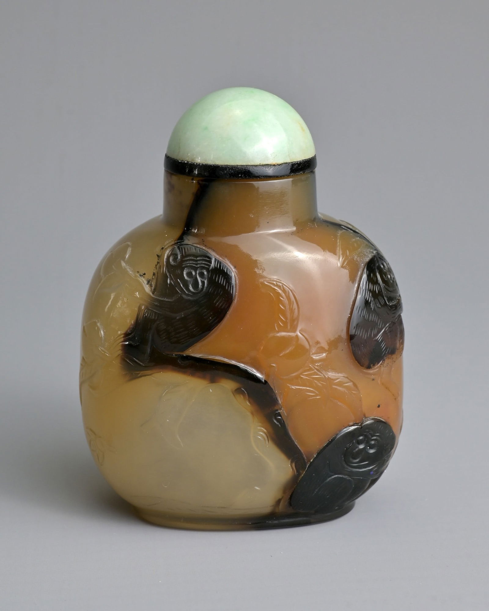 A CHINESE CARVED AGATE SNUFF BOTTLE, 19/20TH CENTURY. Of flattened globular form carved in relief (1 of 7)